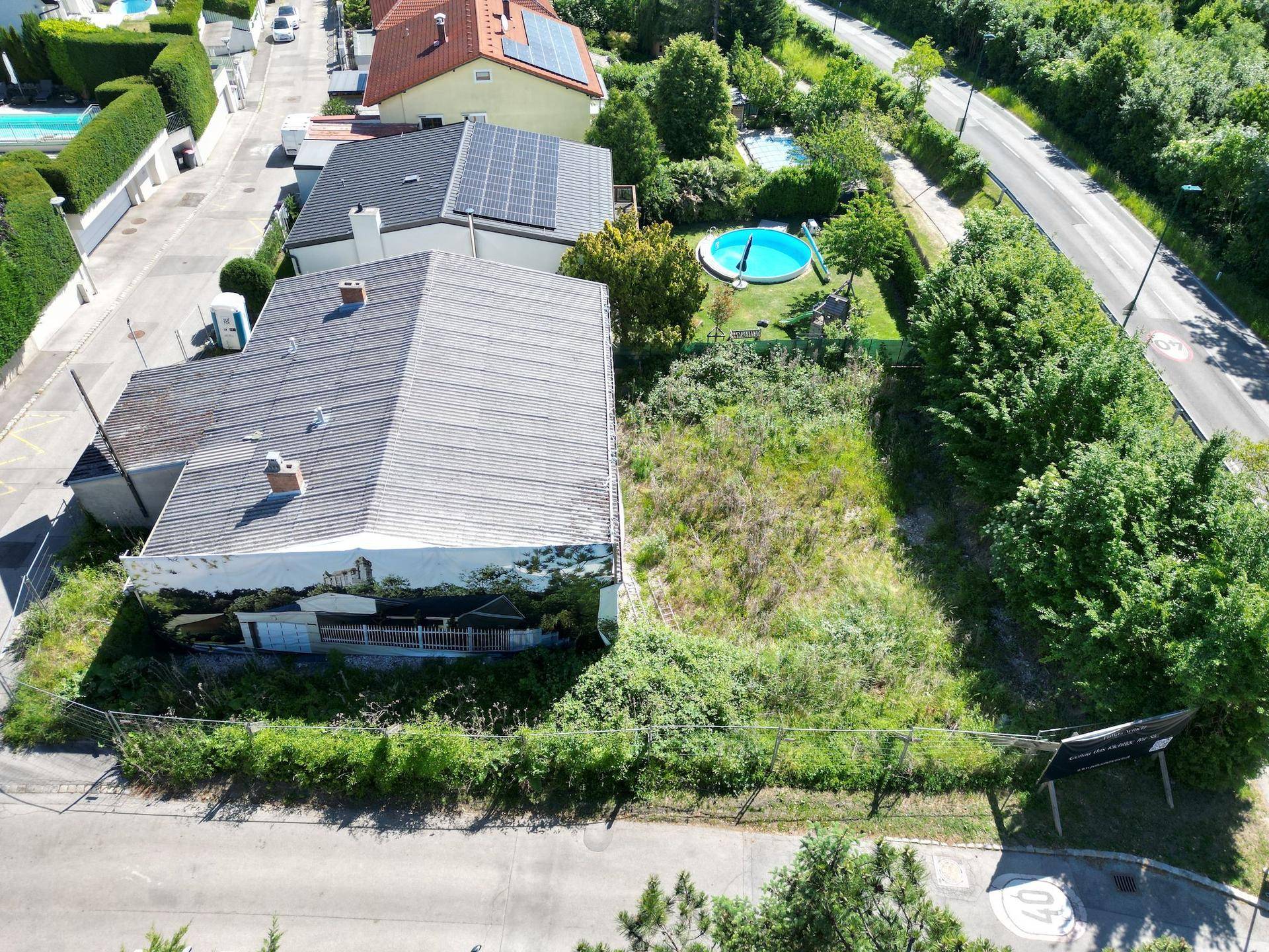Luftaufnahme eines Hauses im Bau mit angrenzendem Grundstück und Blick auf die Nachbarschaft.