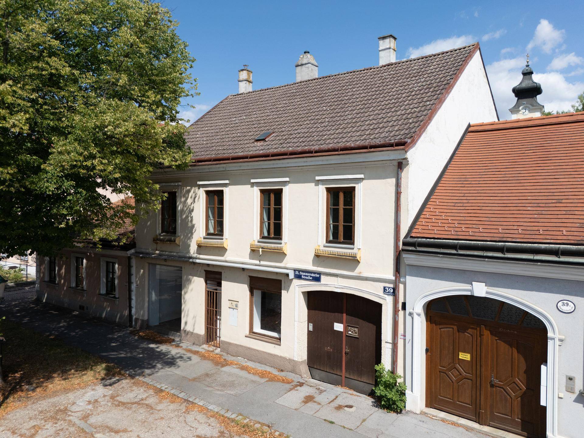 Historisches Gebäude mit Satteldach und traditionellen Fenstern unter blauem Himmel.