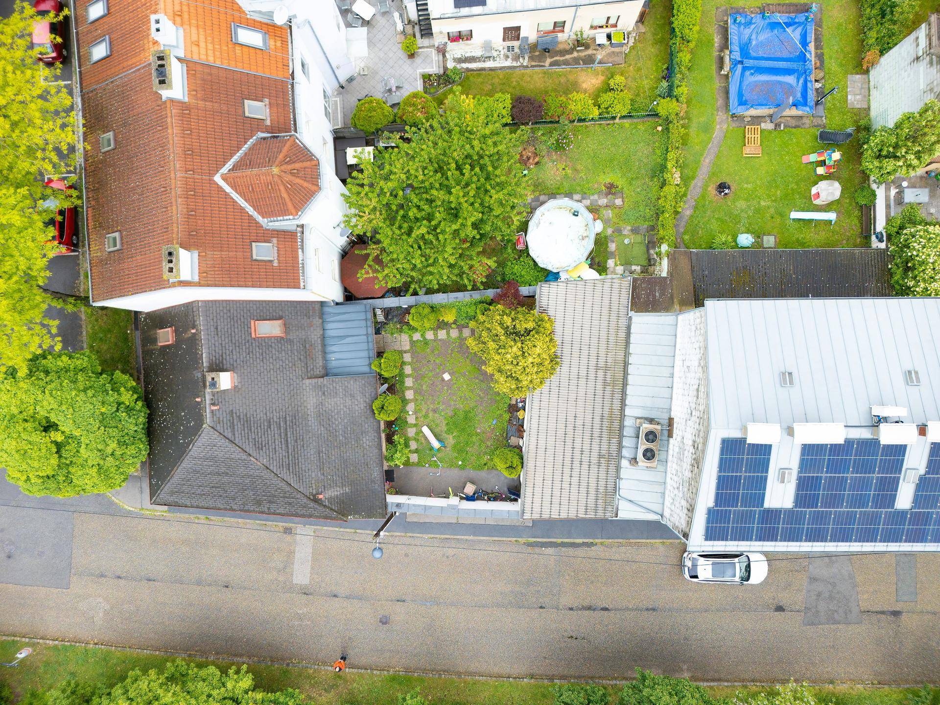 Draufsicht auf das Grundstück mit Wohnhaus, Garten und angrenzenden Nachbargärten.