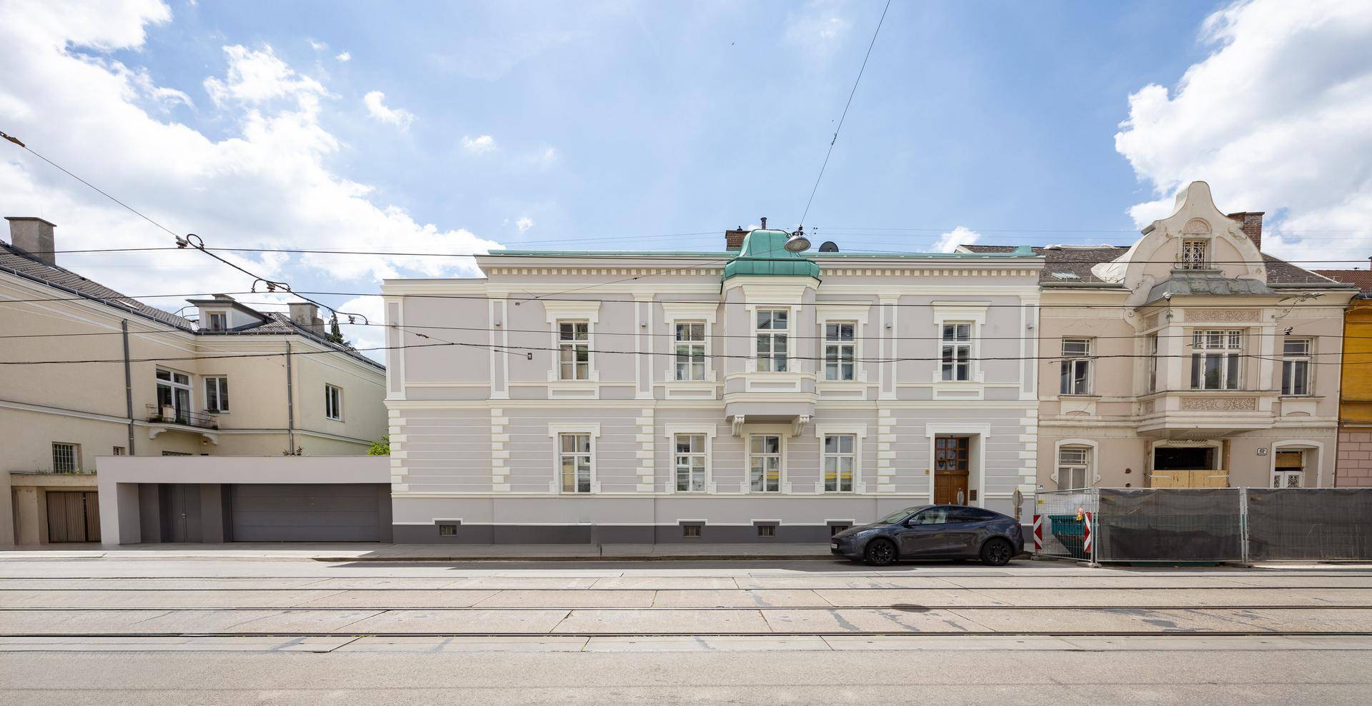 Historisches Gebäude mit klassischer Fassade an einer belebten Straße.