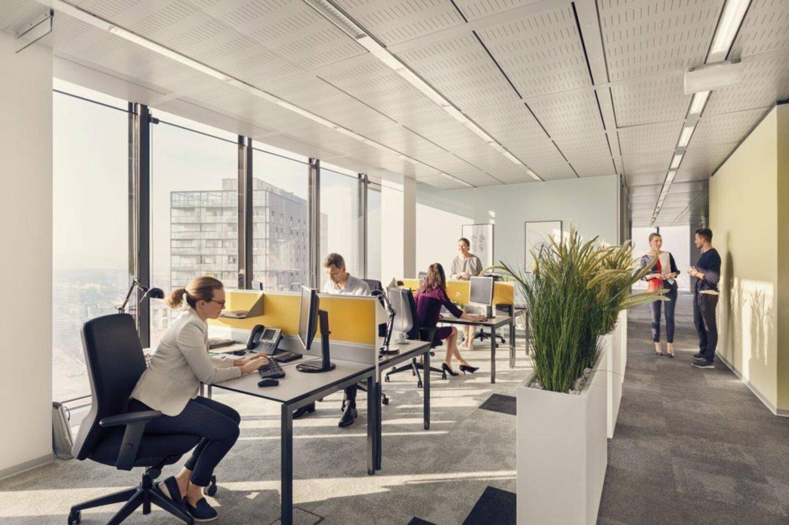 Helles, modernes Großraumbüro mit bodentiefen Fenstern und Blick auf die Stadt, ausgestattet mit ergonomischen Arbeitsplätzen.