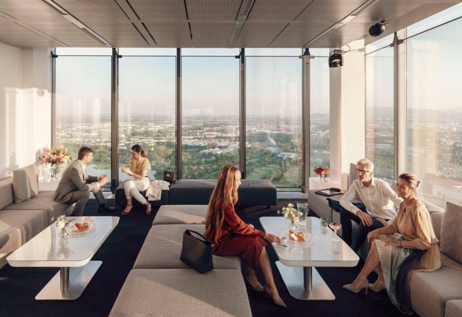 Exklusive Lounge mit bequemen Sitzgelegenheiten und atemberaubendem Weitblick über die Stadt und die umliegende Landschaft.