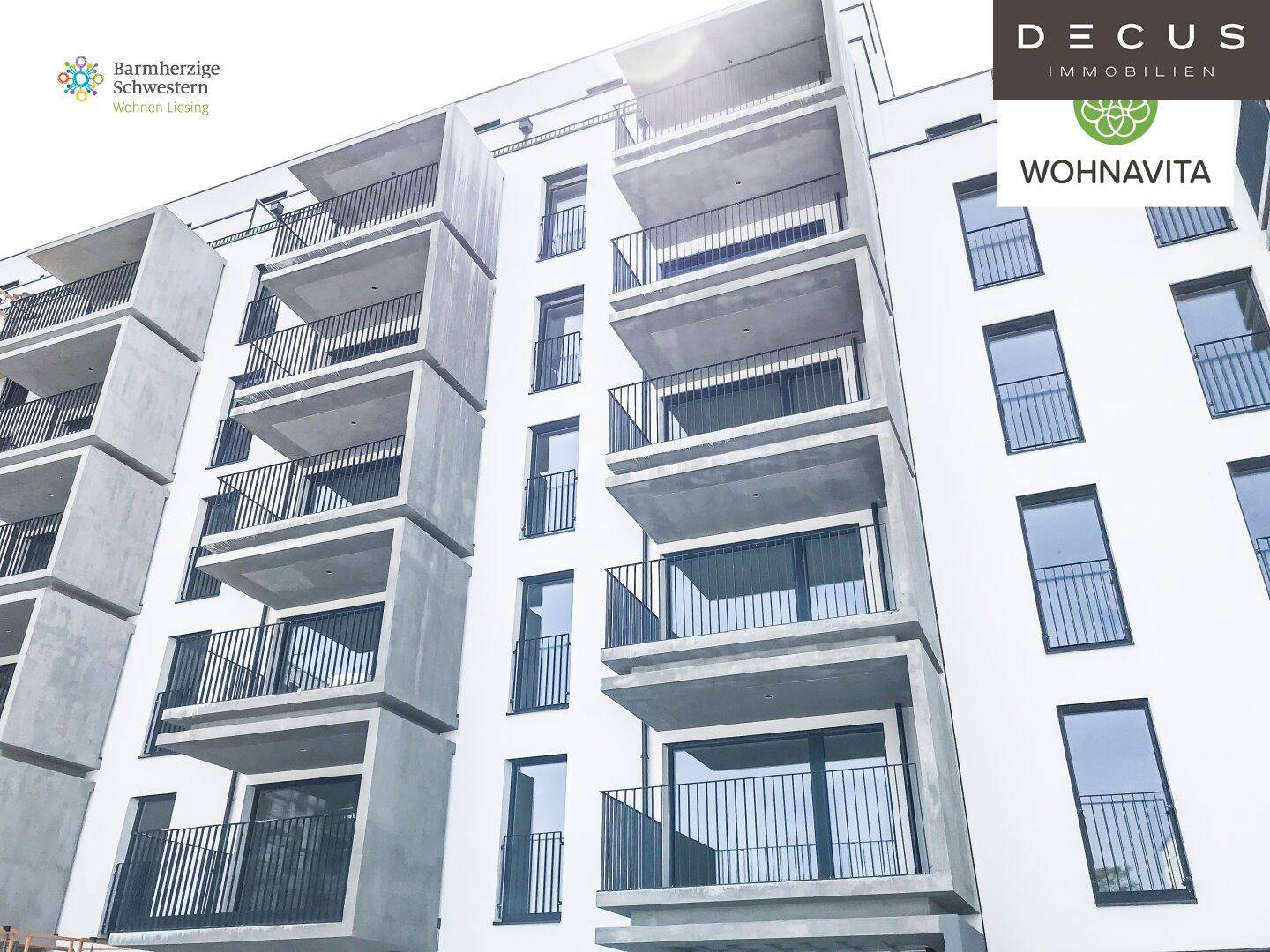 Moderne Wohnhausfassade mit gestuften Balkonen und großen Glasflächen.