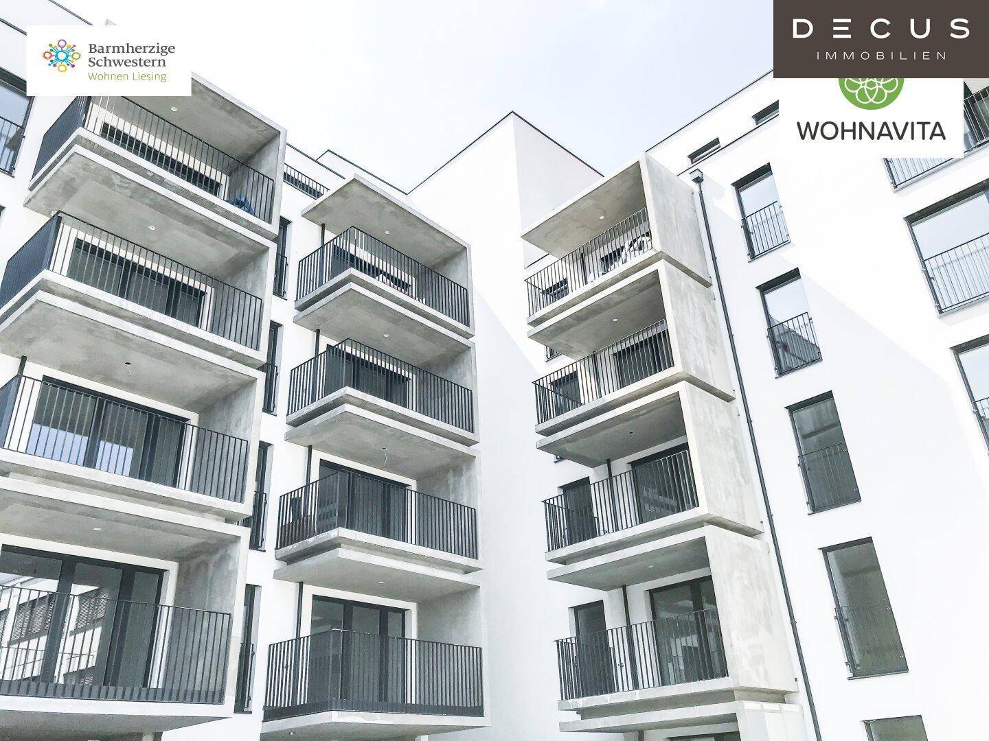 Moderne Gebäudefassade mit zahlreichen Balkonen und großen Fensterfronten.
