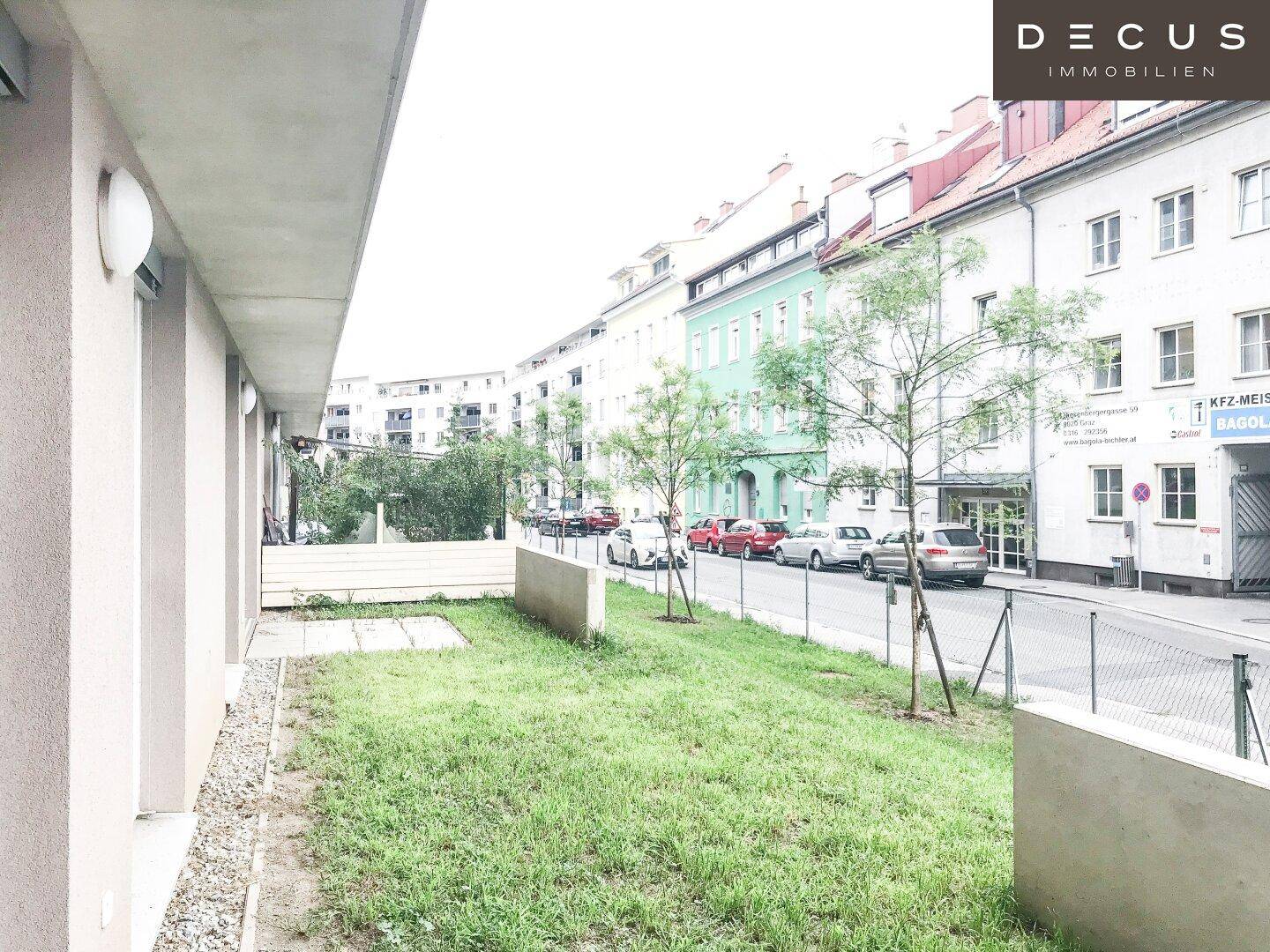 Grünfläche vor dem Gebäude mit Blick auf die umliegende Straße und Nachbarschaft.