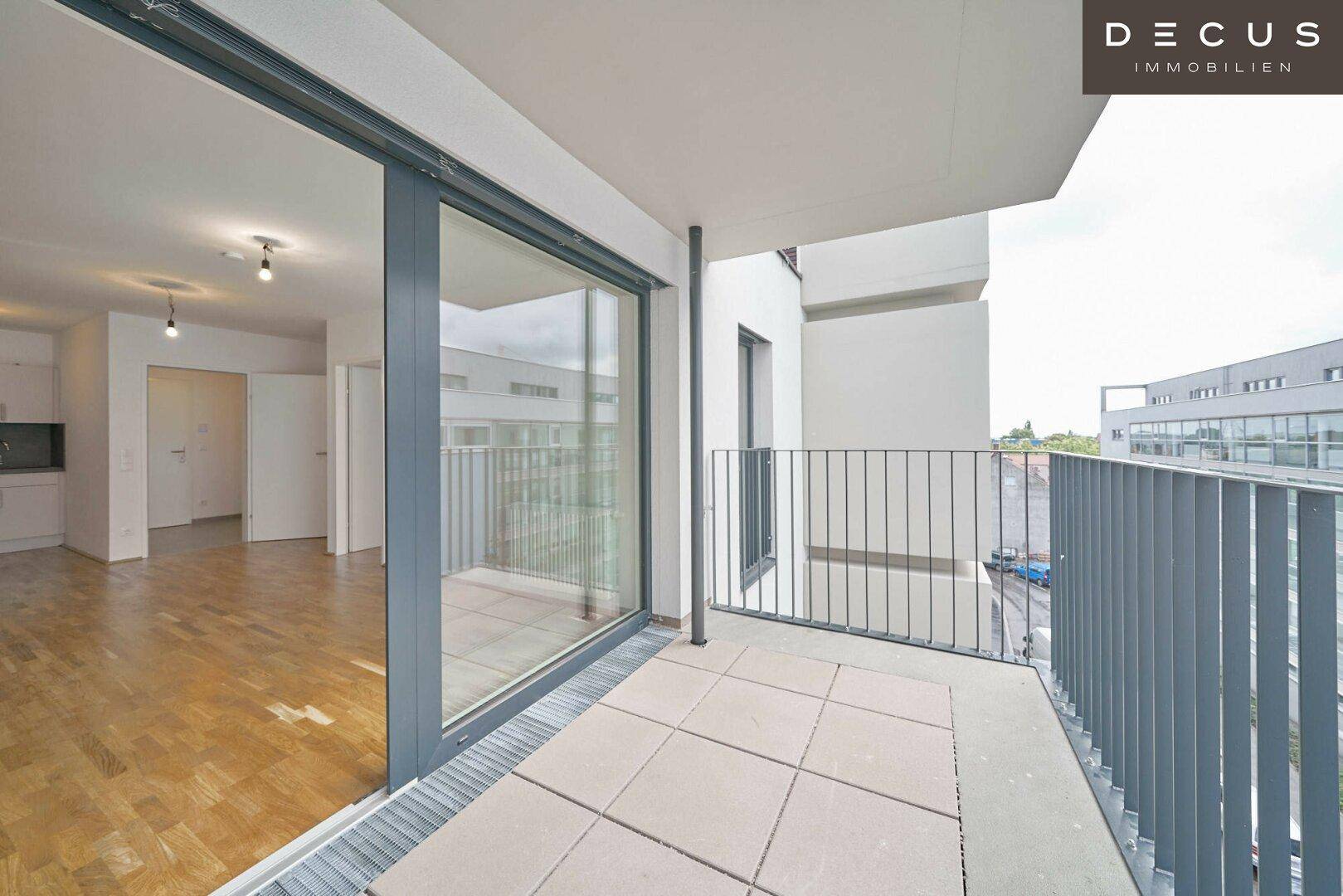Geräumiger Balkon mit Fliesenboden und Blick in den hellen Innenbereich der Wohnung.