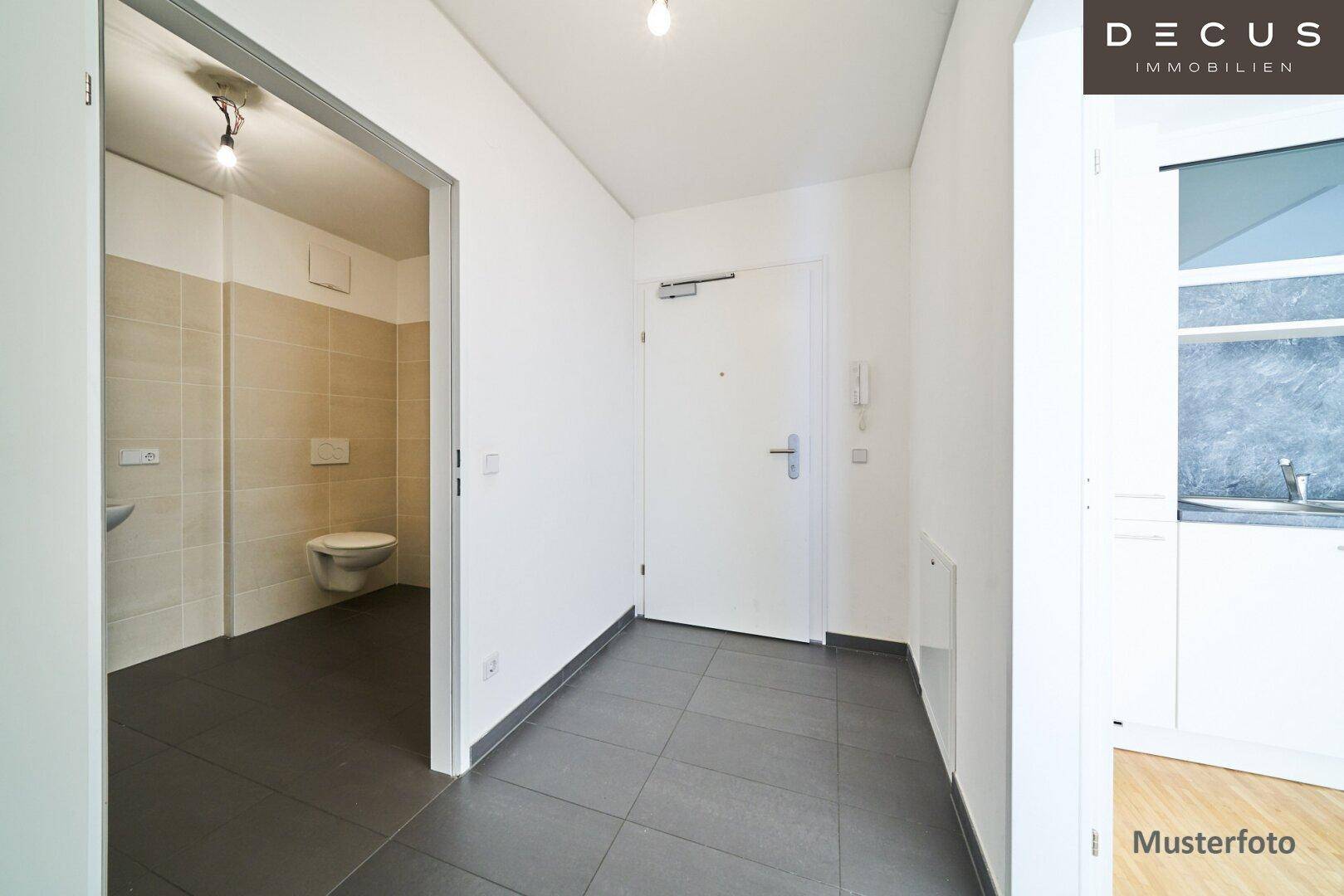 Heller Flur mit Fliesenboden und Zugang zu weiteren Räumen, inklusive Badezimmer.