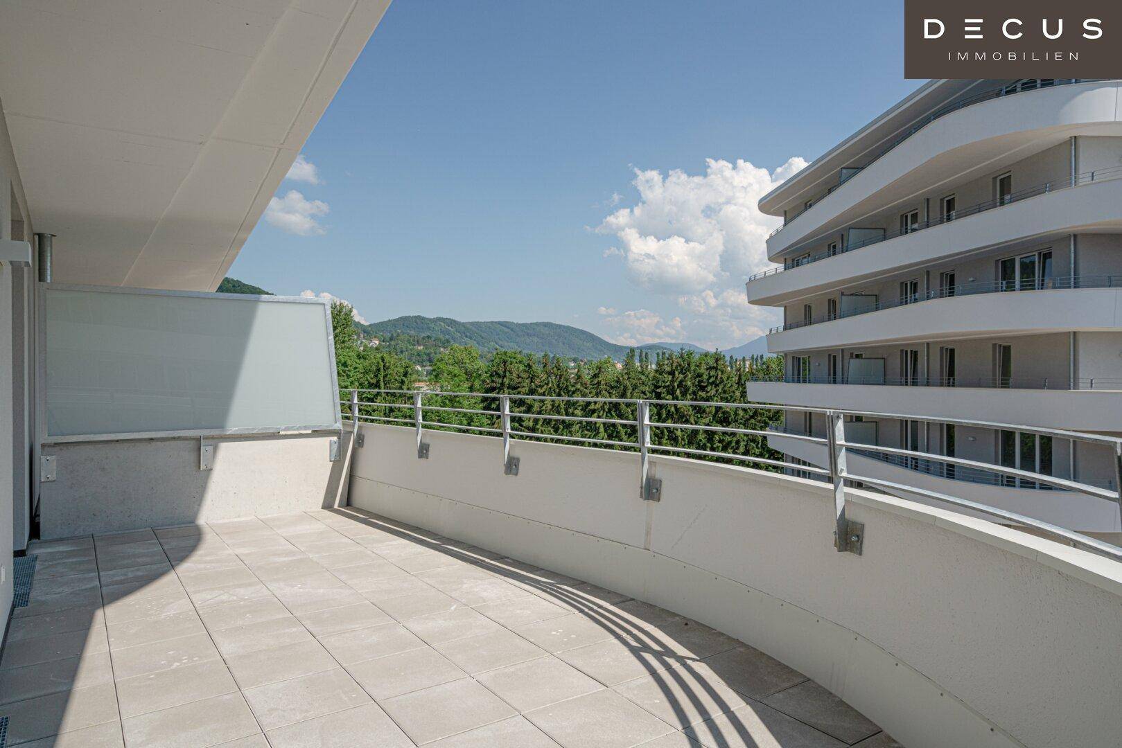 Geräumige Terrasse mit Fliesenboden, Metallgeländer und weitem Blick auf die umliegende Berglandschaft.