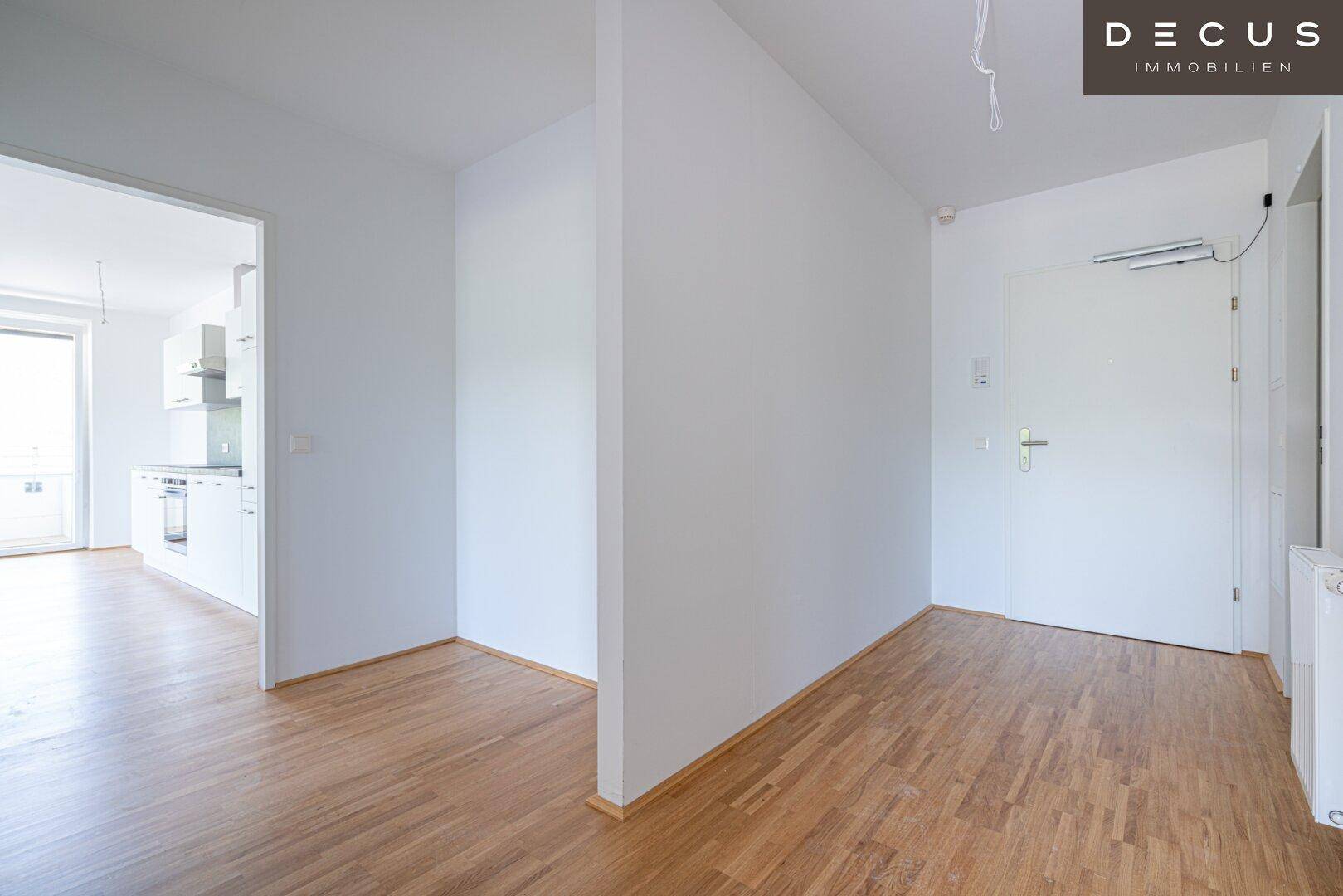 Heller Flur mit Parkettboden und Zugang zu verschiedenen Räumen der Wohnung.