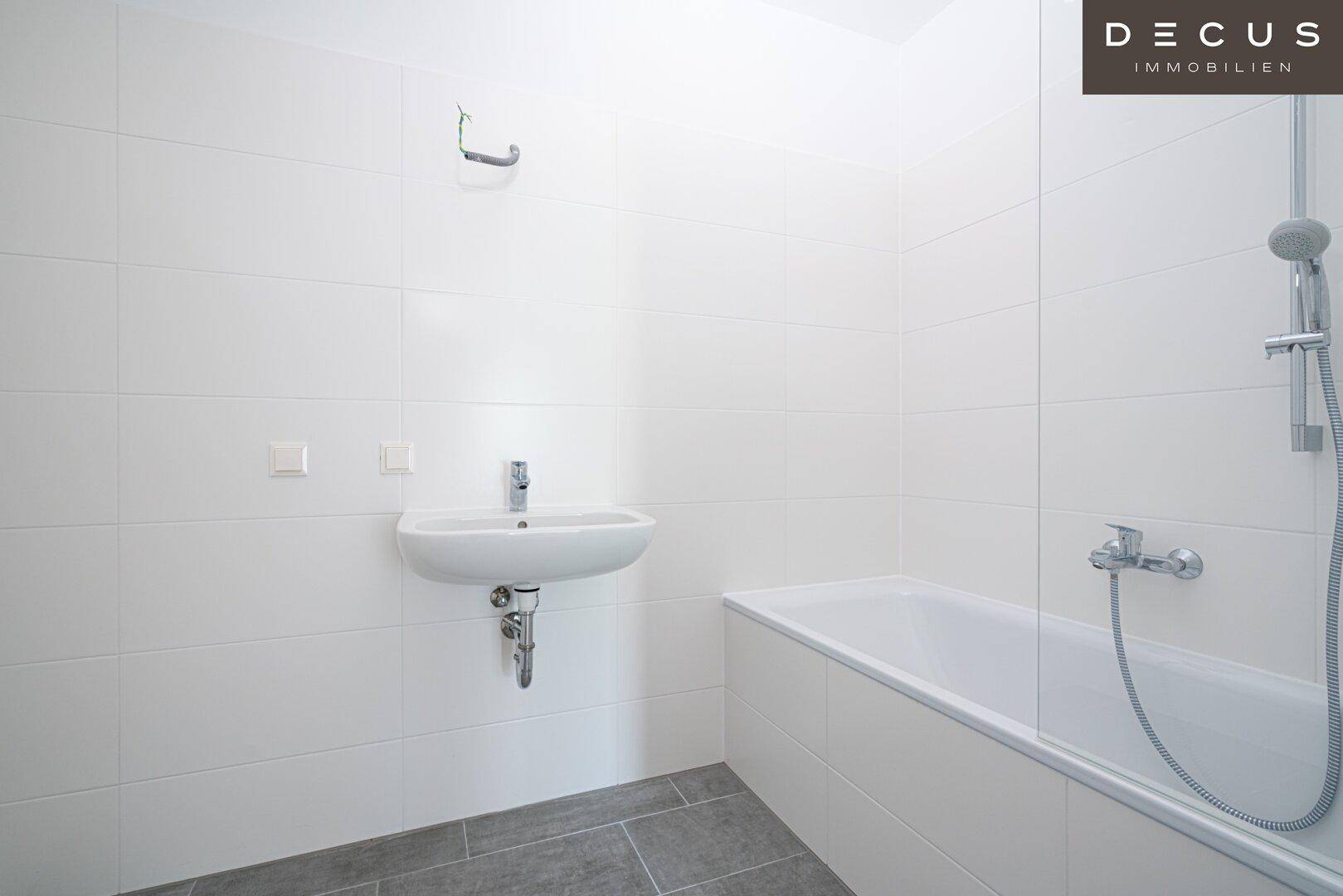 Modernes Badezimmer mit weißen Fliesen, Badewanne und Waschbecken, bereit für die Endmontage.