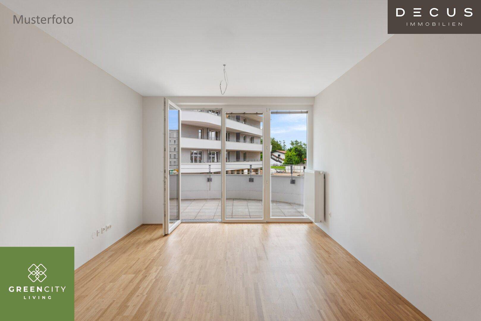 Helles, leeres Wohnzimmer mit Holzboden und großen Fenstern zum Balkon.