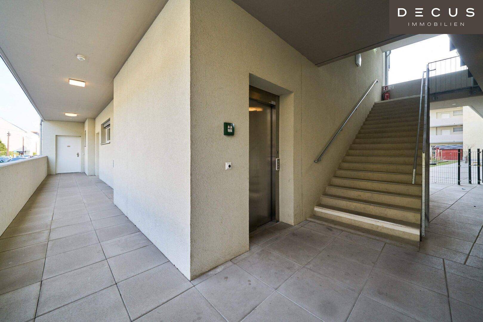 Heller Flur im Mehrfamilienhaus mit Aufzug und Treppenhauszugang zu den Wohneinheiten.