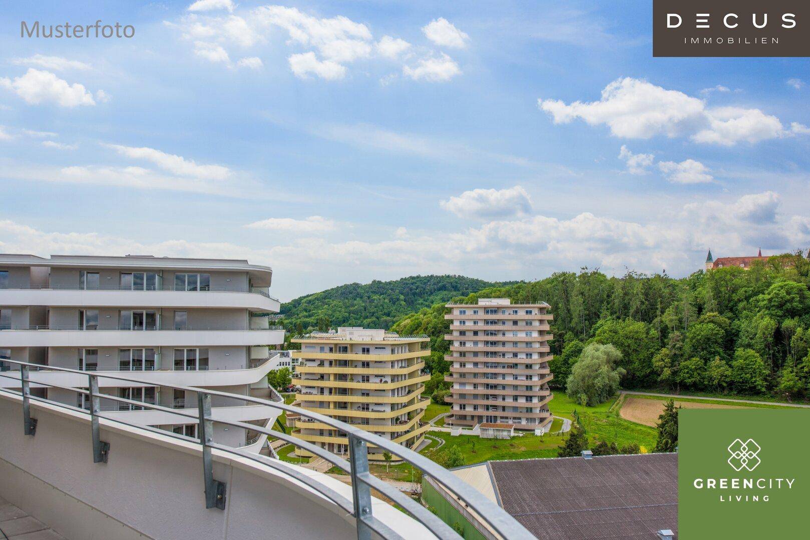 Weitläufiger Blick vom Balkon auf grüne Hügel, weitere Gebäude und die umliegende Landschaft.