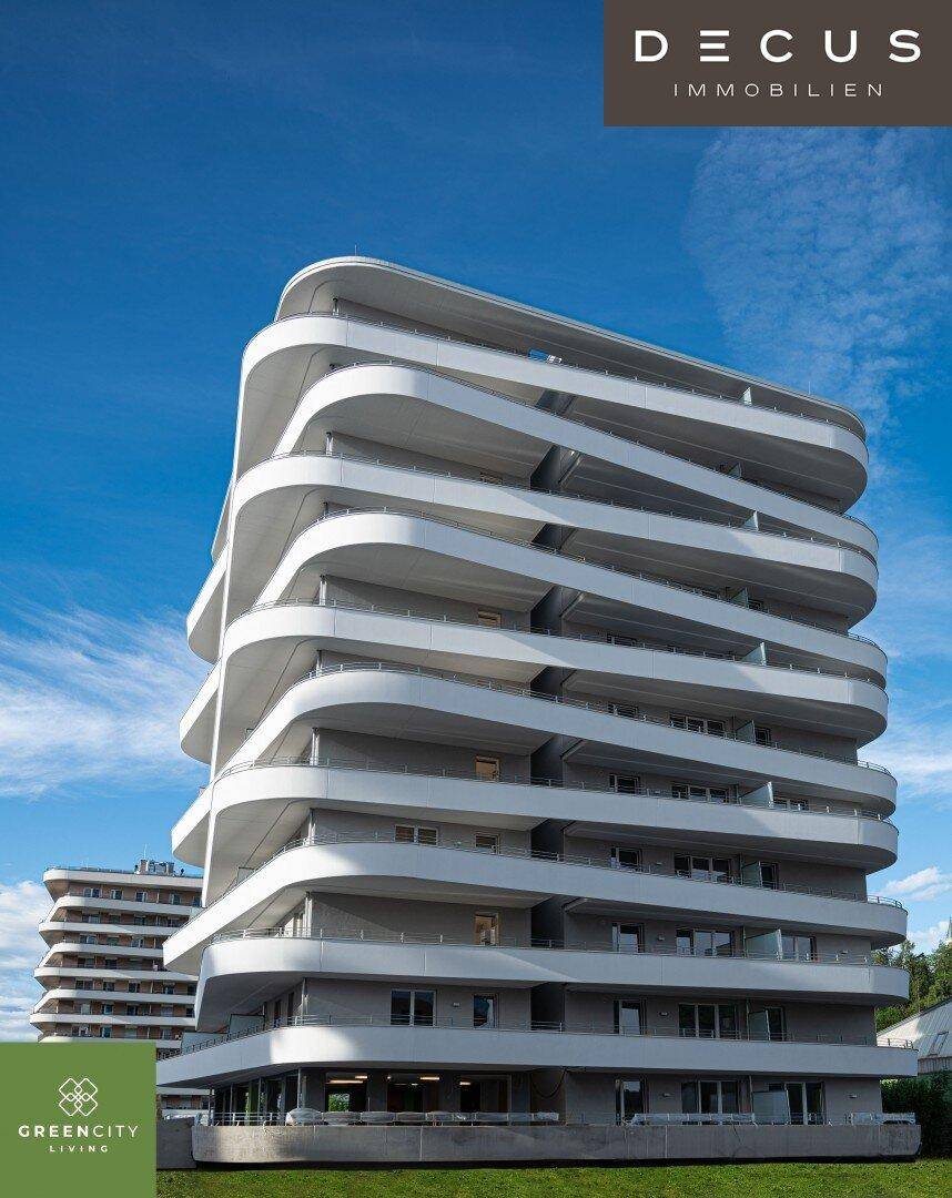 Beeindruckendes modernes Wohngebäude mit geschwungenen Balkonen und klarer Architektur unter blauem Himmel.