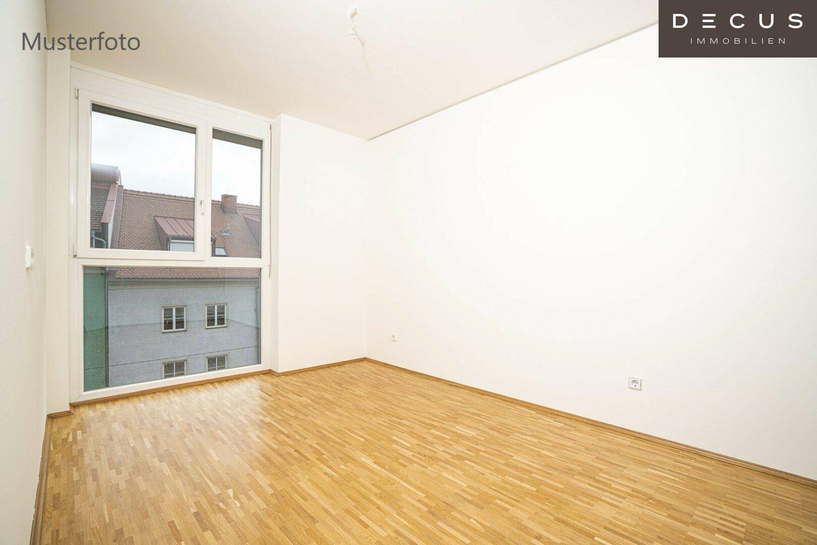 Geräumiges, leeres Zimmer mit Parkettboden und großen Fenstern, die viel Tageslicht hereinlassen.