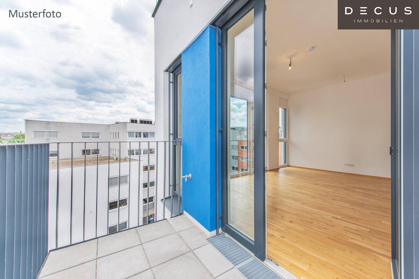 Helles Wohnzimmer mit Holzboden und Zugang zu einem gefliesten Balkon mit Stadtblick.