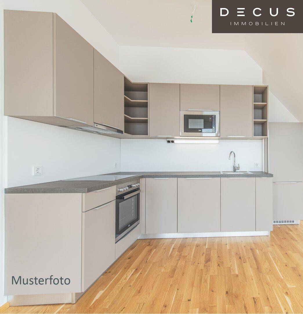 Moderne Einbauküche in Beige mit integrierten Geräten und Holzboden in einem hellen Raum.