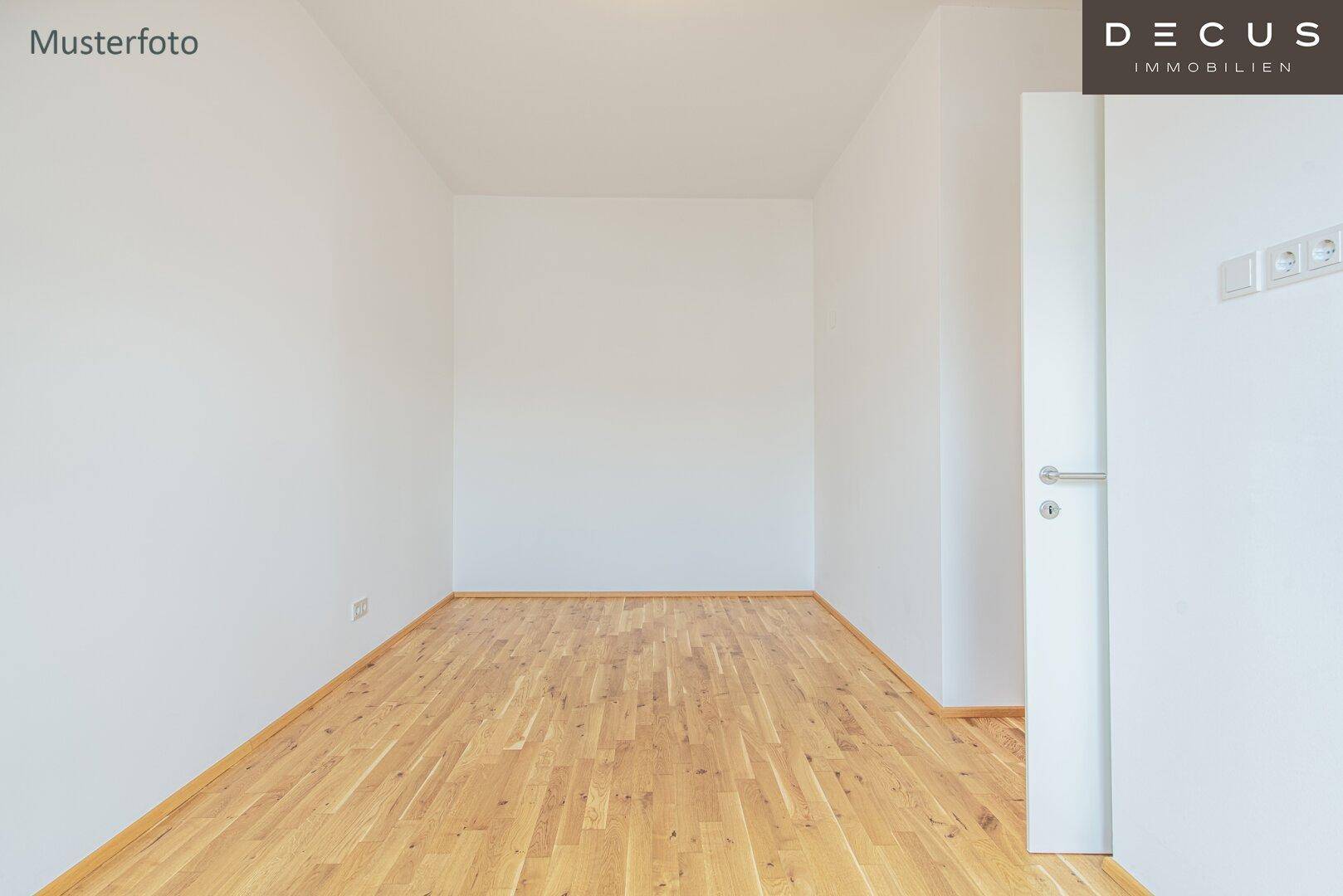 Leerer, heller Raum mit Holzboden und weißen Wänden, bereit zur individuellen Gestaltung.