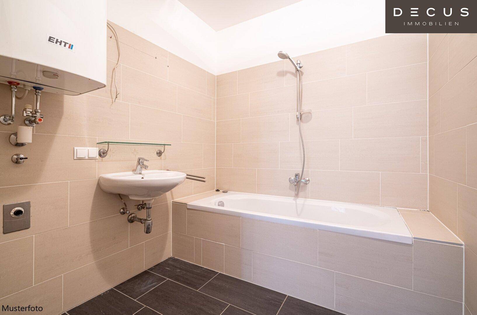 Modernes Badezimmer mit beigefarbenen Fliesen, Badewanne und einem Wandwaschbecken.