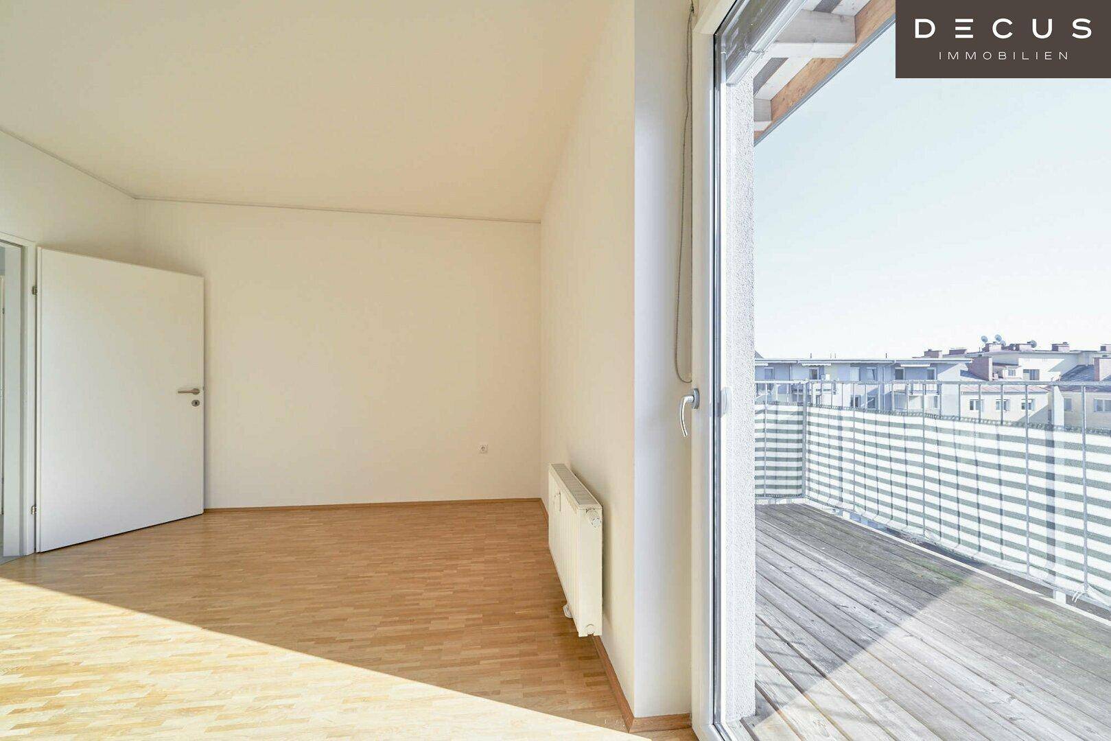 Heller Raum mit Parkettboden und Zugang zu einem Balkon, ideal für natürliches Licht.