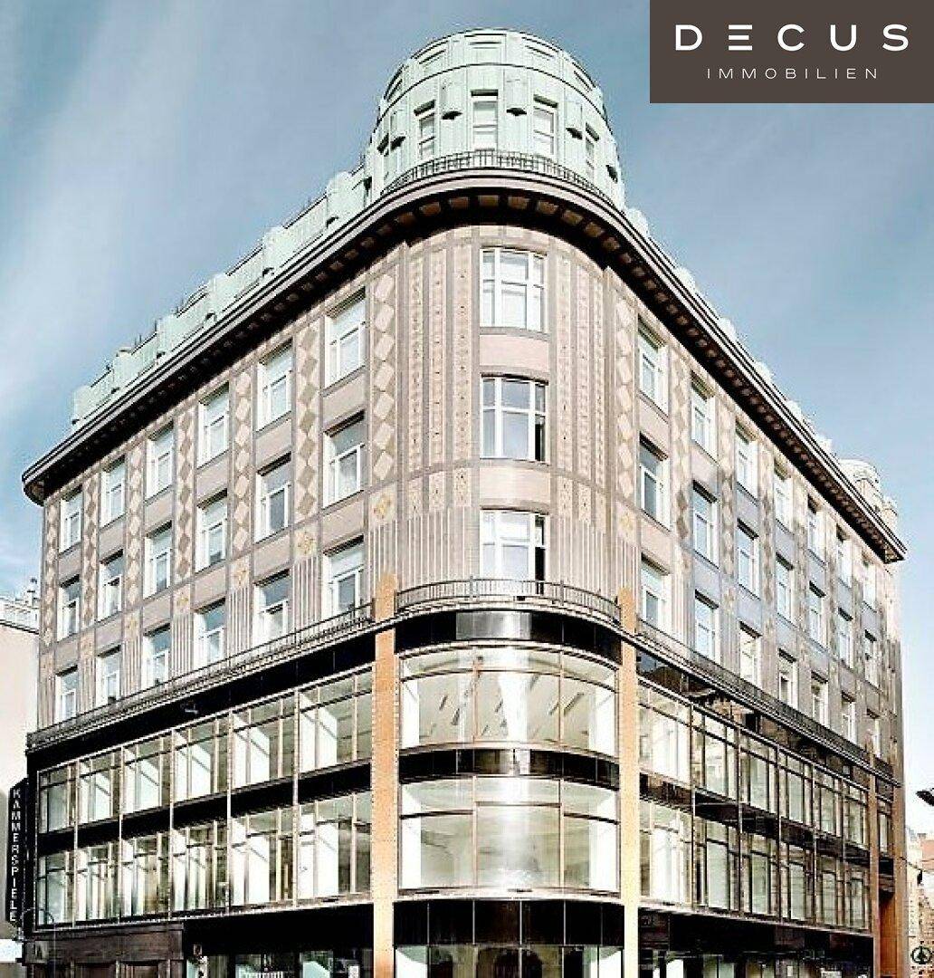 Markantes Eckgebäude mit runder Kuppel und großen Glasflächen im Erdgeschoss, prägnante Architektur.