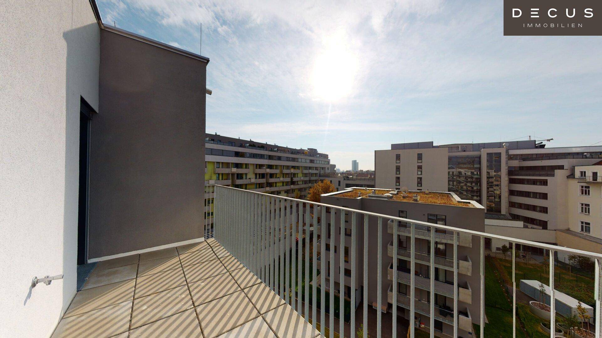 Heller Balkon mit Fliesenboden und weitem Blick auf die städtische Umgebung und andere Gebäude.