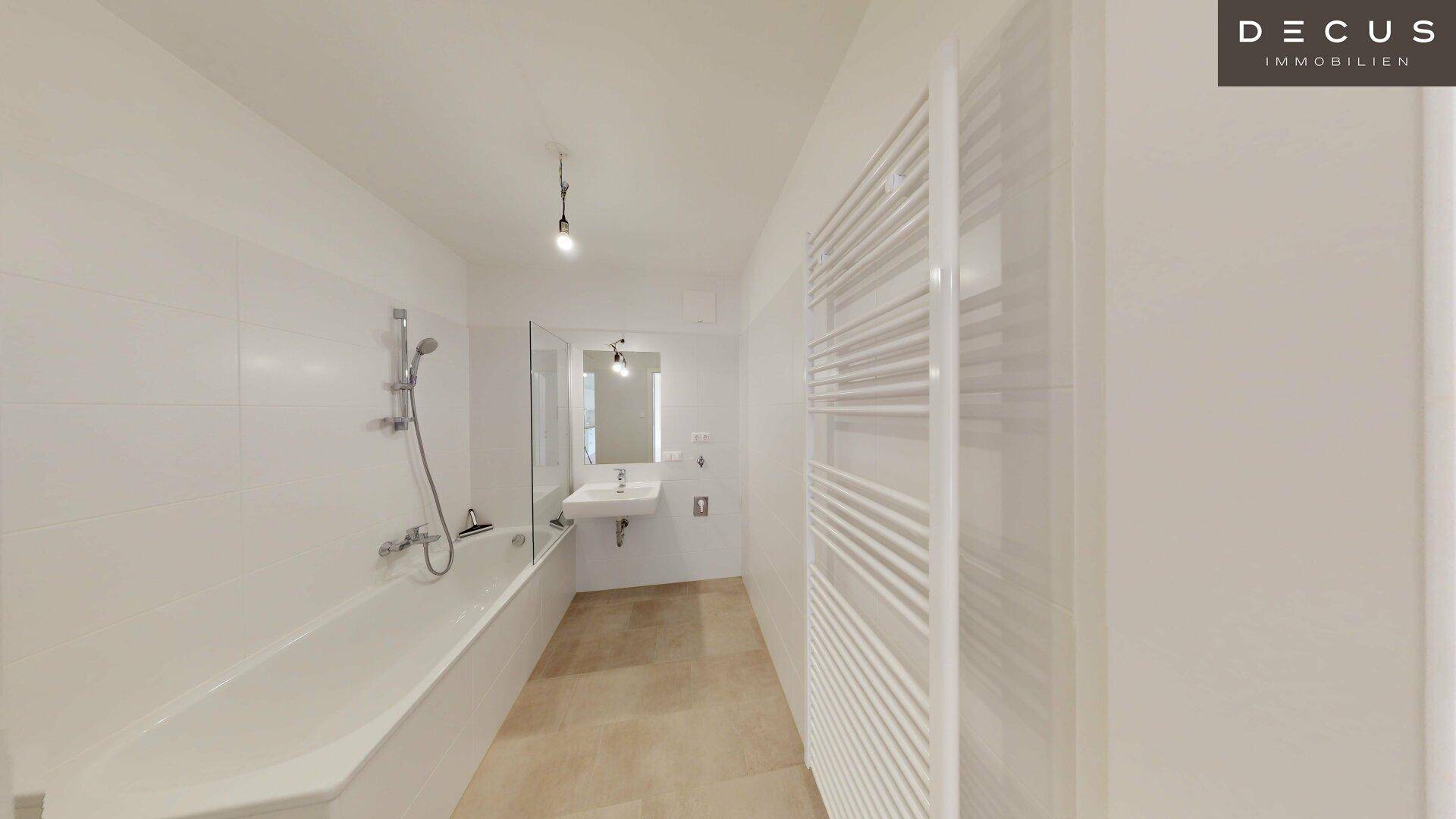 Geräumiges Badezimmer mit Badewanne, Einzelwaschbecken und beheiztem Handtuchhalter.