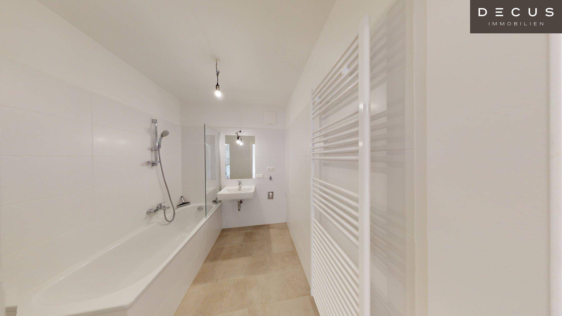 Modernes Badezimmer mit Badewanne, Duschvorrichtung und Handtuchheizkörper.