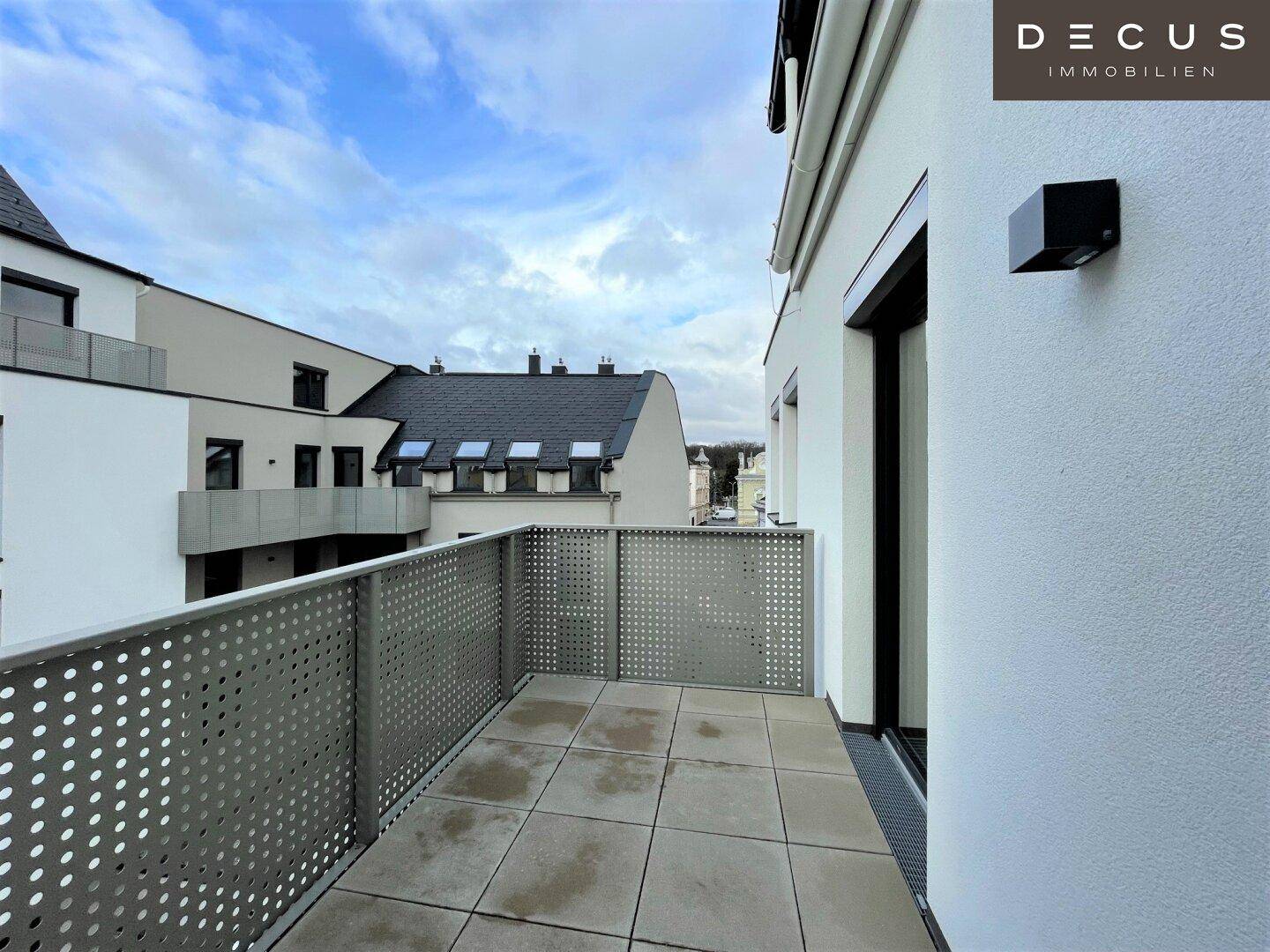 Geräumige Terrasse mit Fliesenboden und moderner Metallbrüstung, bietet einen Blick auf die Umgebung.