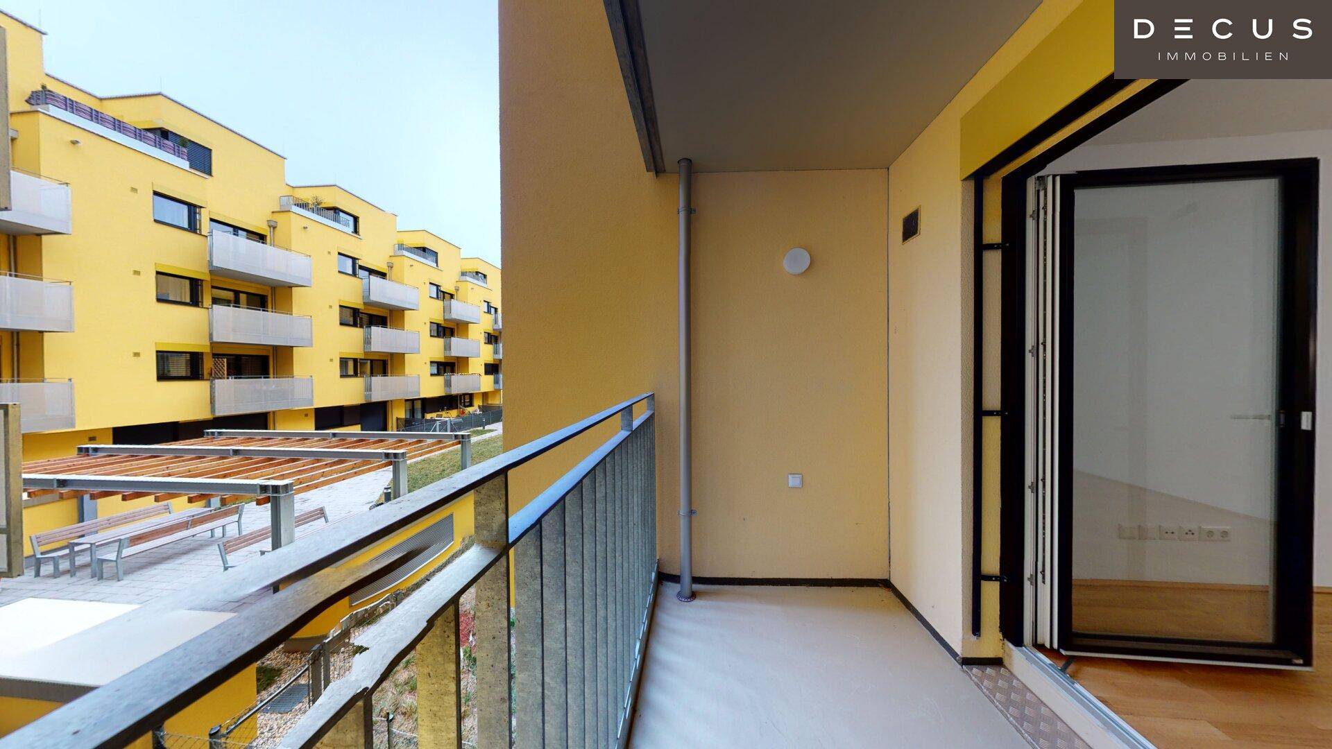 Balkon mit Blick auf den Innenhof und die moderne Architektur des Gebäudes.