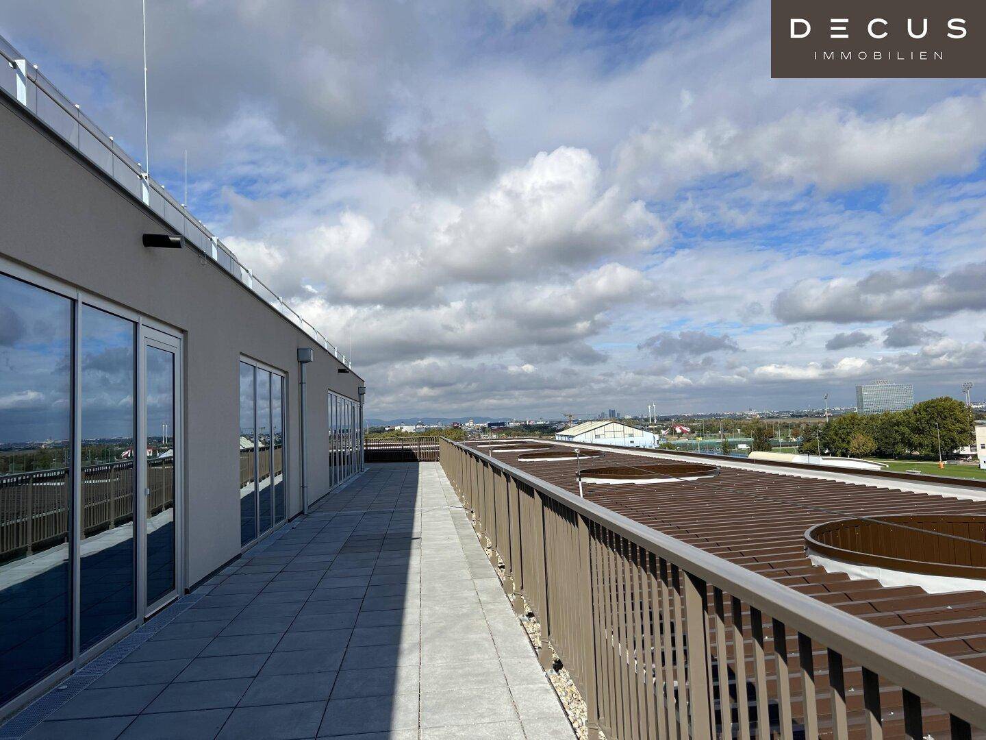Weitläufige Dachterrasse mit Panoramablick über die Stadt und die umliegende Landschaft.