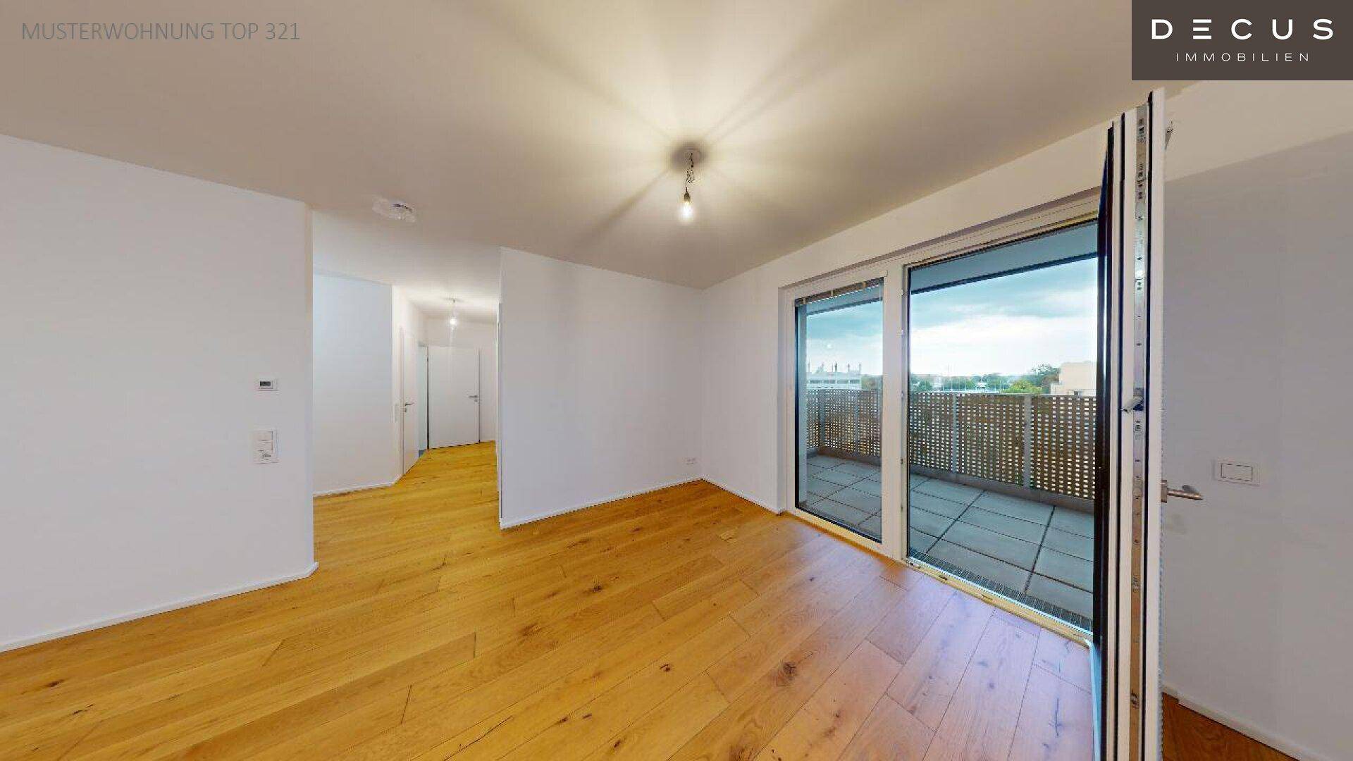Heller Wohnbereich mit Holzboden und Zugang zu einem sonnigen Balkon.