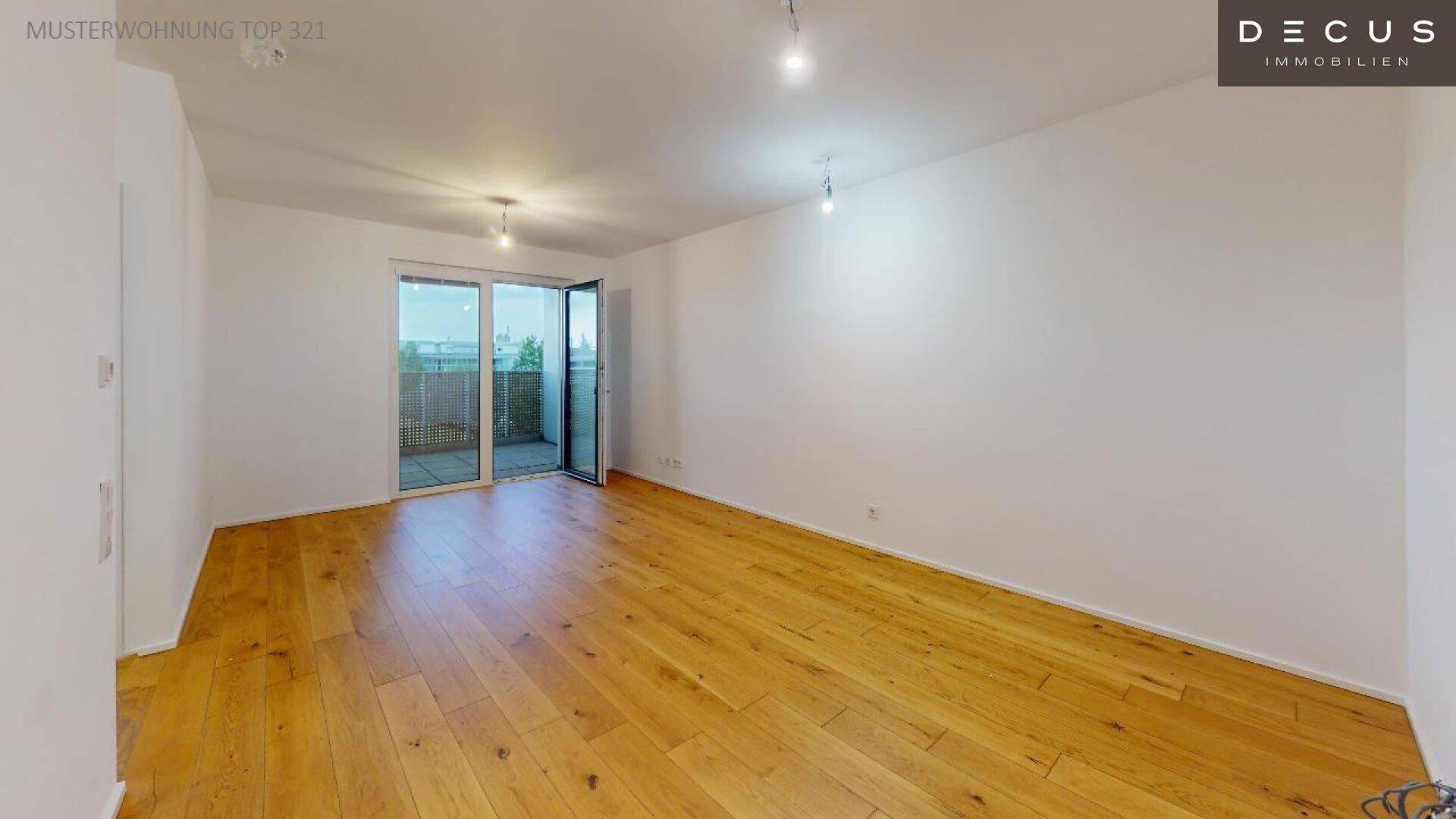 Großer, heller Wohnraum mit Holzboden und Schiebetür zum Außenbereich.