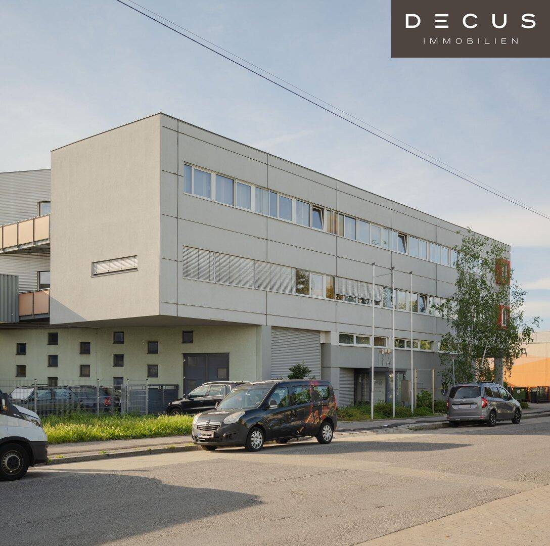 Ansicht des modernen Bürogebäudes mit heller Fassade und vielen Fenstern unter blauem Himmel.