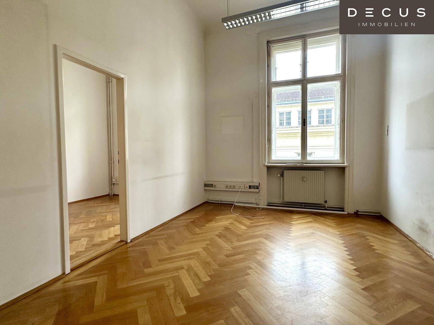Kleineres Büro mit Fischgrätparkett und einem Fenster, ideal für Einzelarbeitsplätze.