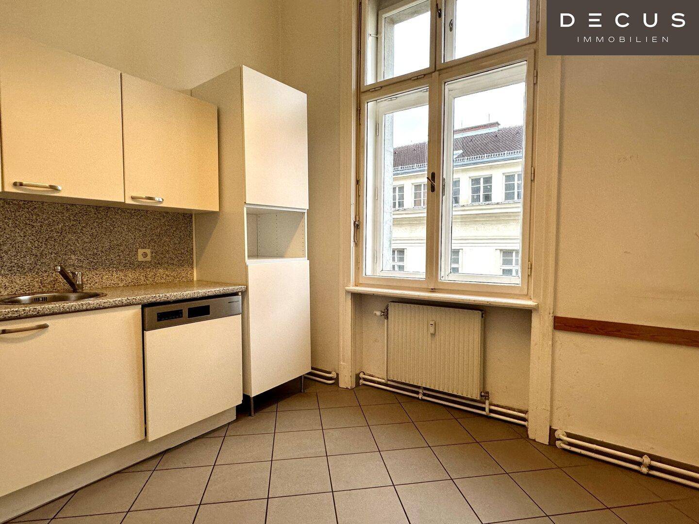 Funktionale Küchenzeile mit weißen Schränken, Spüle und Geschirrspüler, ideal für Pausen.