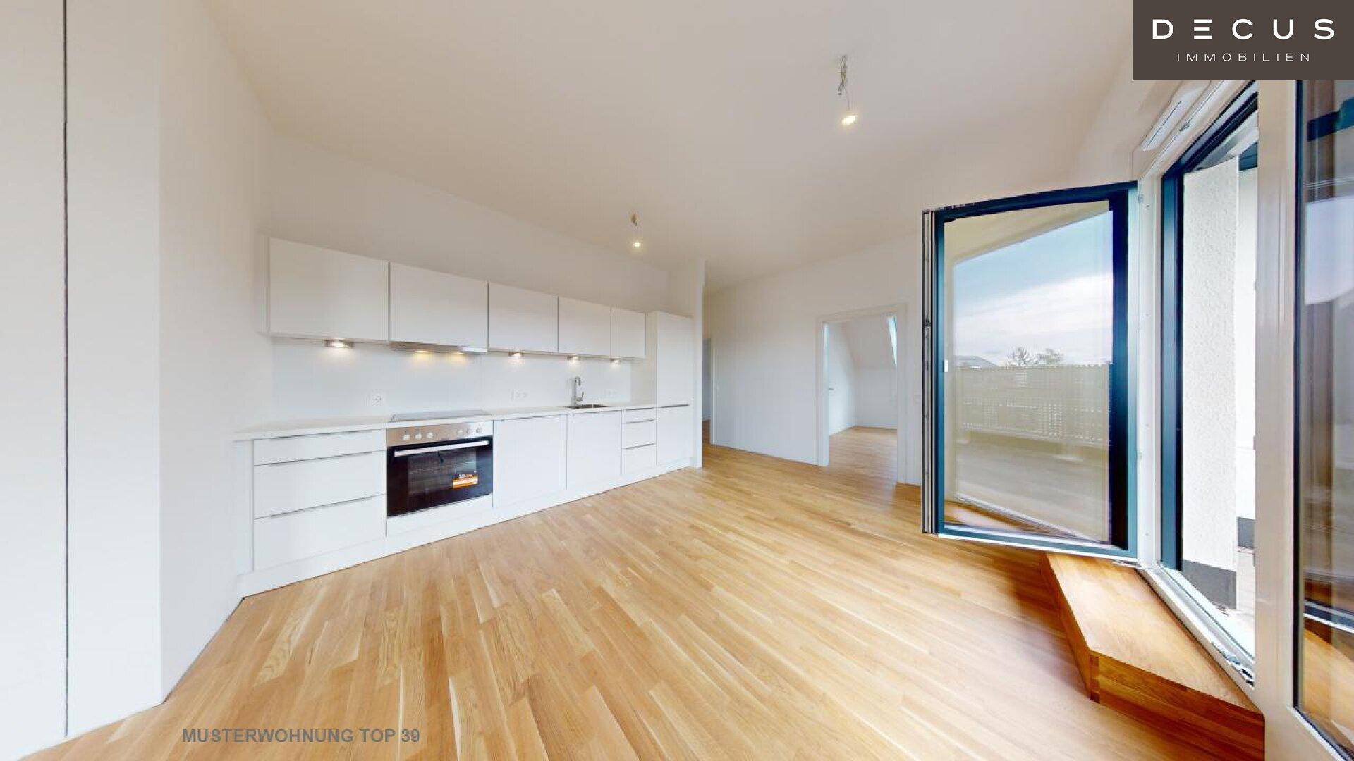 Lichtdurchfluteter Wohnbereich mit offener Küche und Zugang zu einem Balkon.