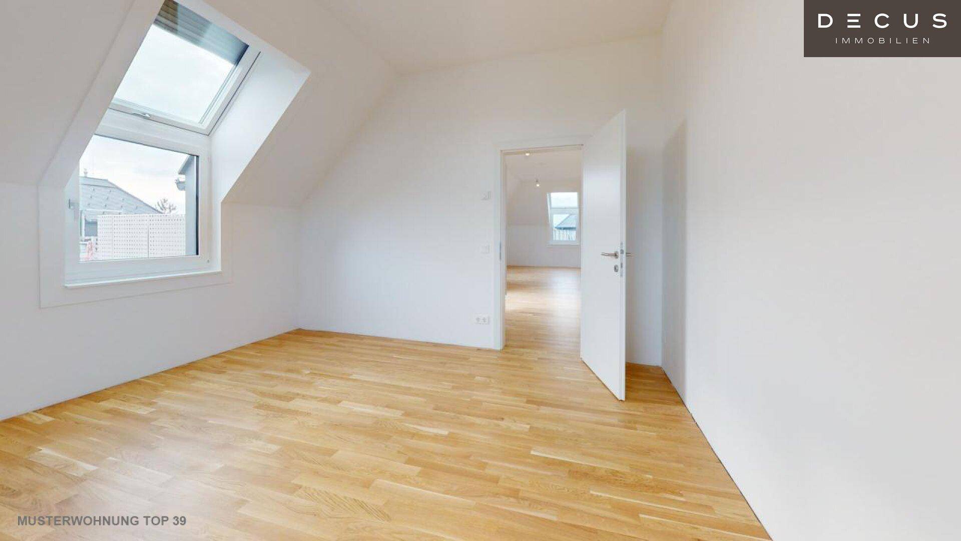 Geräumiges Schlafzimmer im Dachgeschoss mit Parkettboden und Dachfenster.