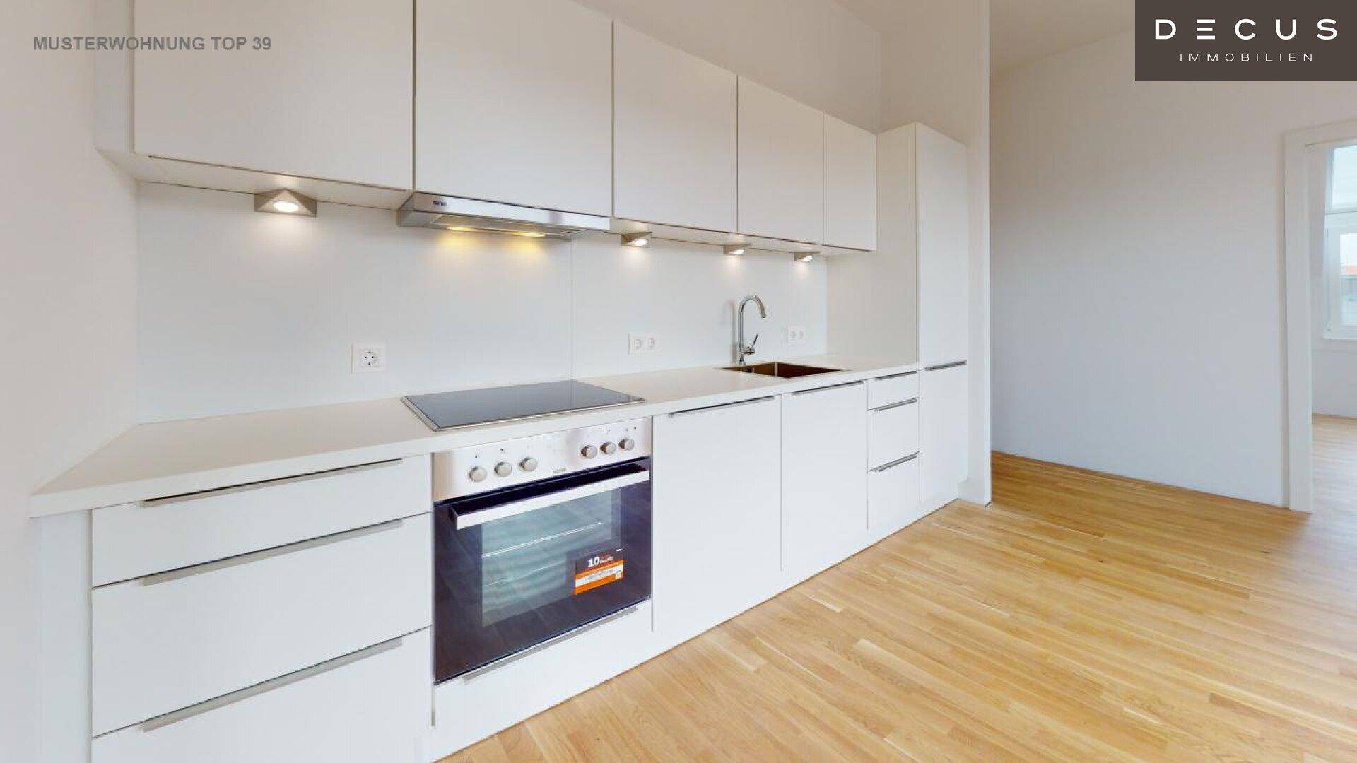Moderne Küchenzeile mit weißen Schränken, Induktionskochfeld und Backofen.