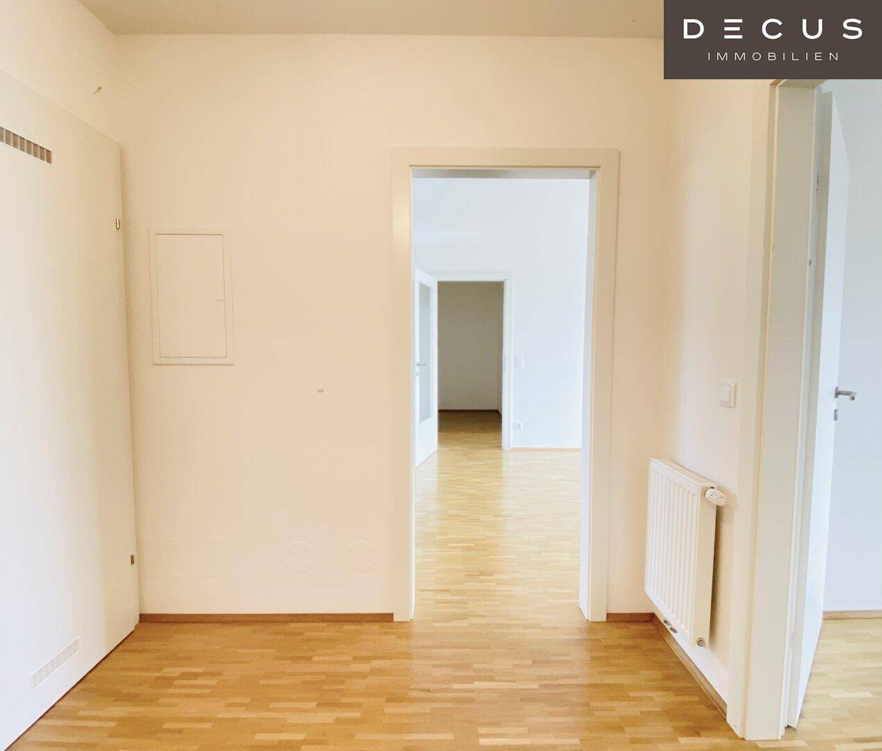 Heller Flur mit Parkettboden und Zugang zu verschiedenen Zimmern der Wohnung.