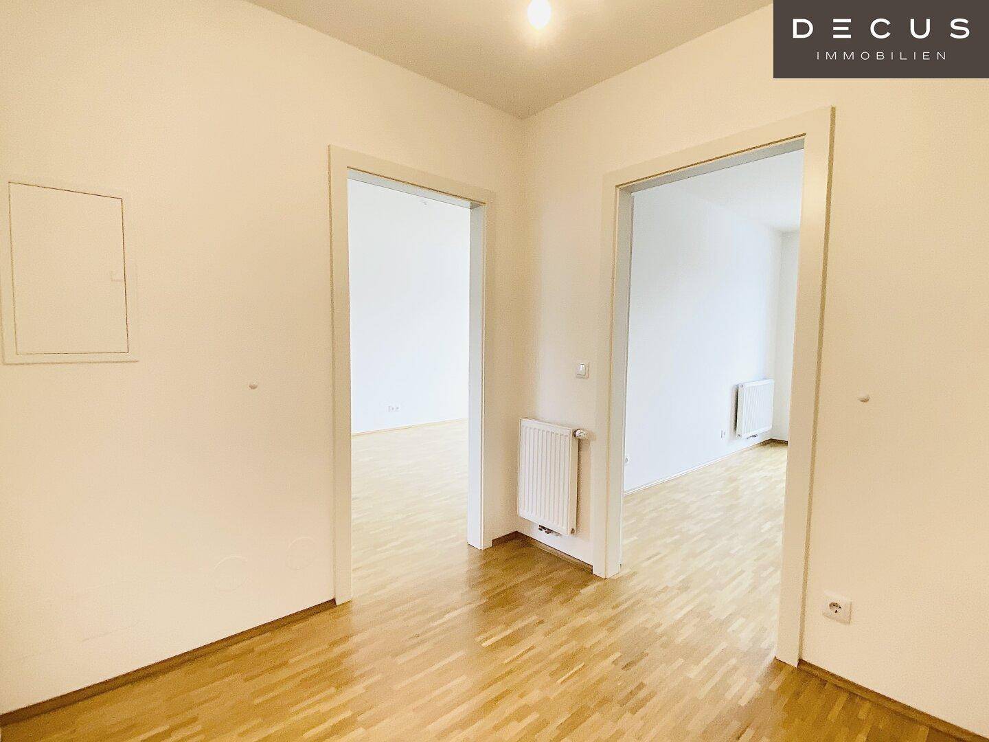 Geräumiger Flur mit Parkettboden und offenen Türen, die den Blick in weitere Räume freigeben.