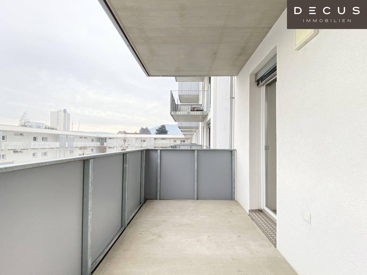Geräumiger Balkon mit moderner Brüstung und Blick auf die umliegende Wohnbebauung.