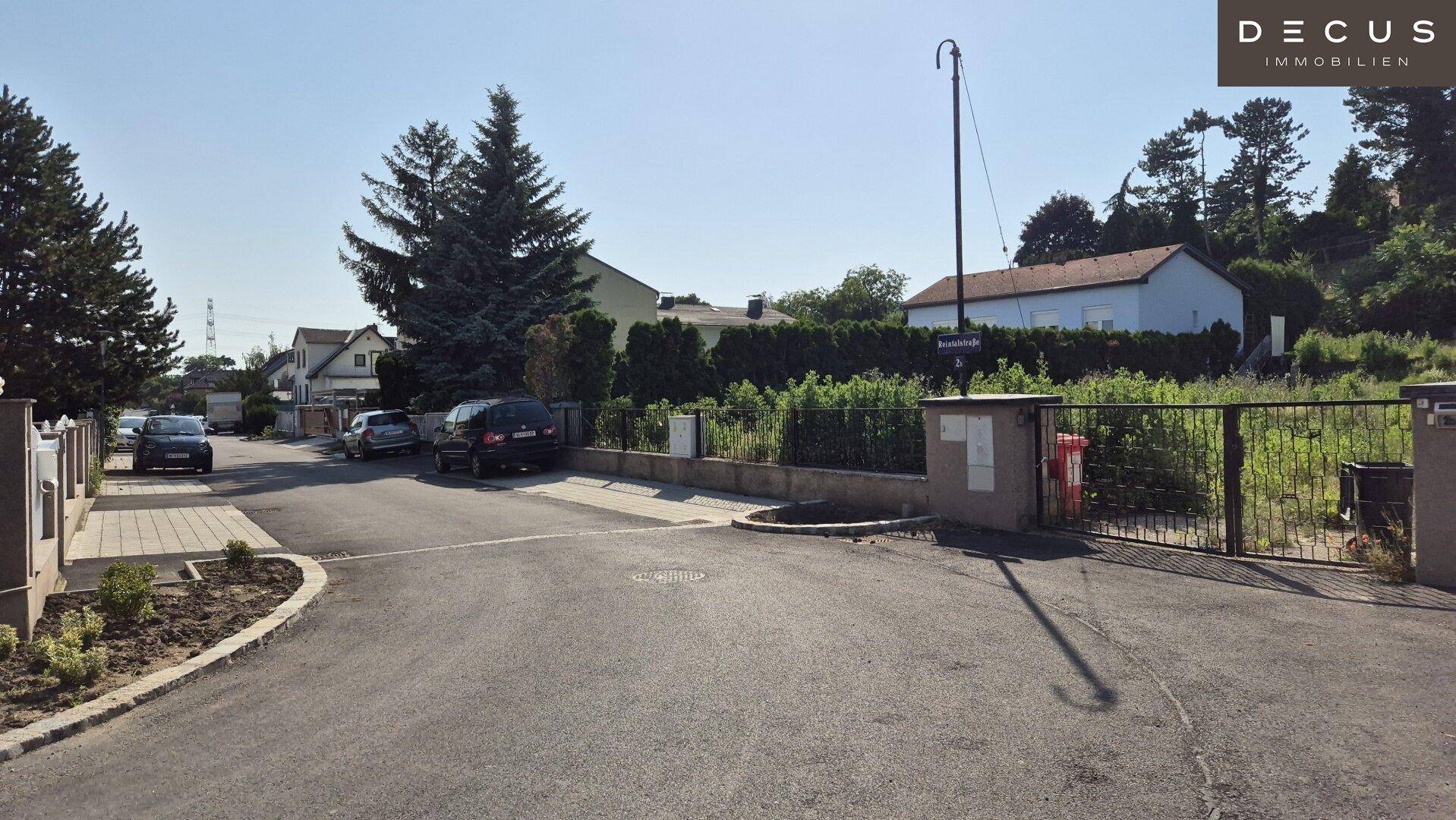 Großes, unbebautes Grundstück mit üppiger Vegetation und umliegenden Wohnhäusern im Hintergrund.