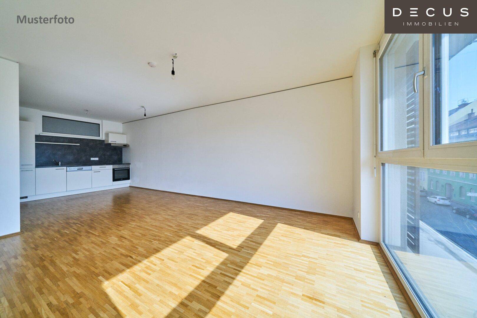 Lichtdurchfluteter offener Wohnbereich mit Parkettboden und großen Fenstern.