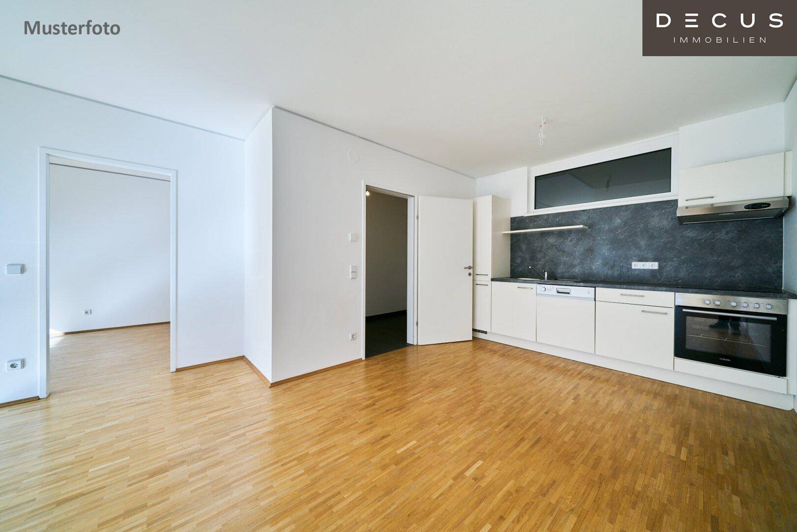 Heller Wohnbereich mit moderner Küchenzeile und Parkettboden, ideal für offenes Wohnen.