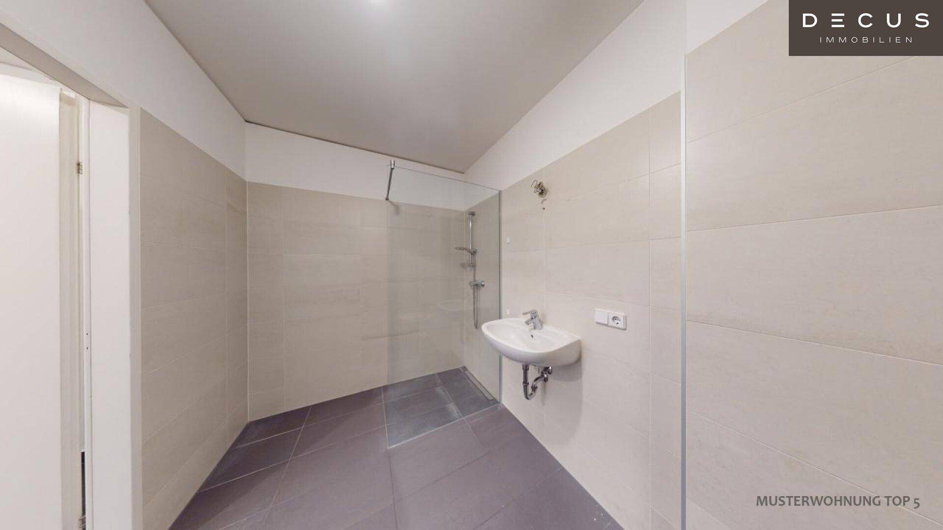 Modernes Badezimmer mit Duschbereich und Waschbecken, bereit zur individuellen Gestaltung.