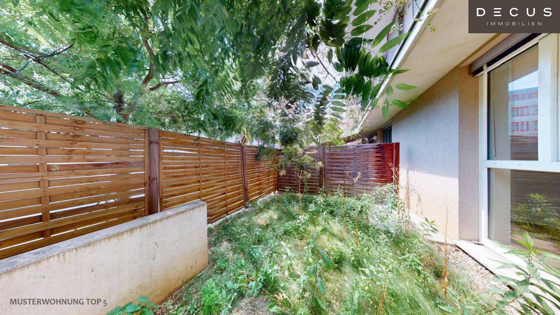 Kleiner privater Gartenbereich mit Holzzaun und Grünflächen, ideal zum Entspannen.