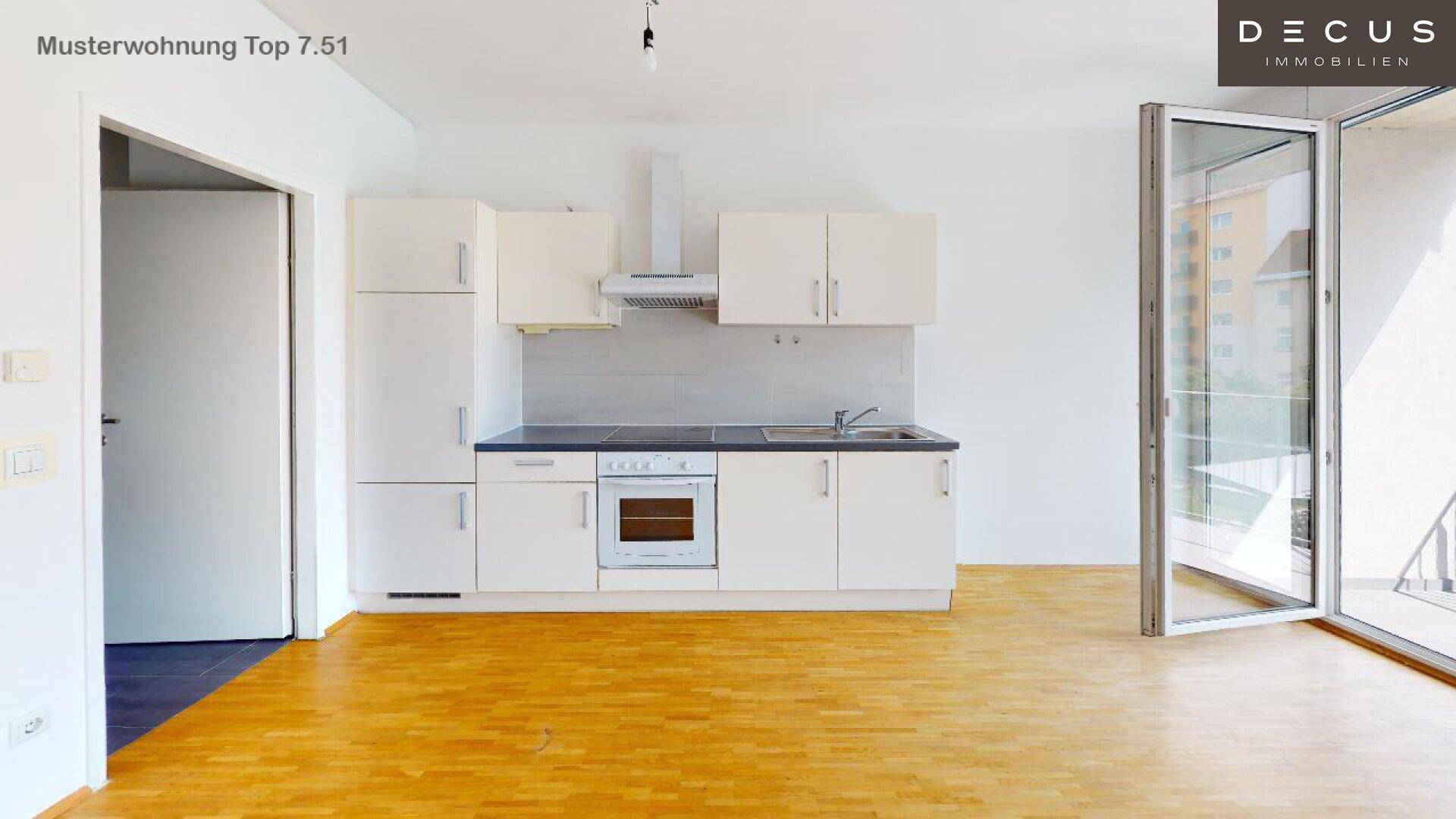Moderne Einbauküche in Weiß mit integrierten Geräten und Holzboden in einem offenen Raum.