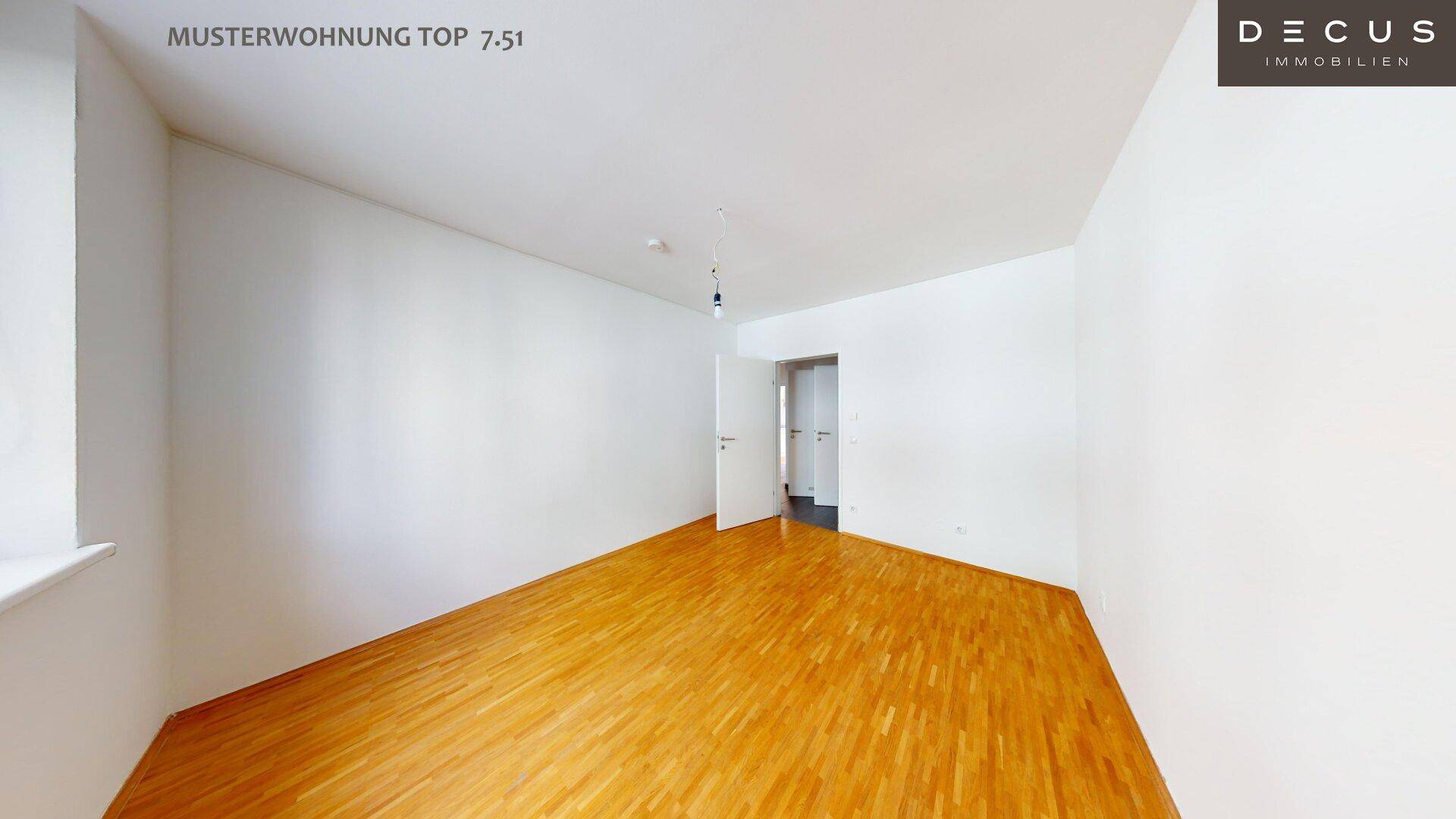 Leeres Schlafzimmer mit hellem Holzboden und weißen Wänden, bereit zur individuellen Gestaltung.