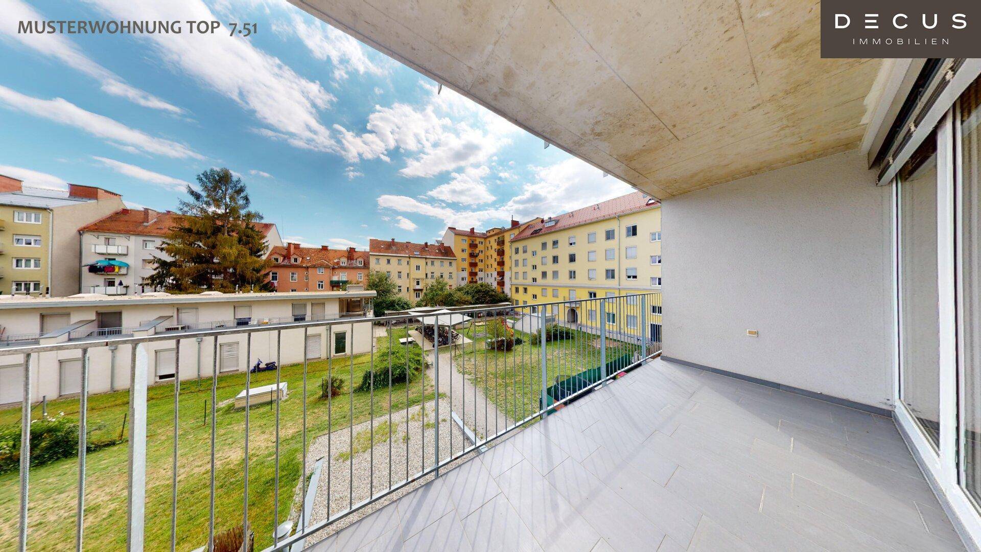 Geräumiger Balkon mit Fliesenboden und Metallgeländer, bietet einen Blick auf den grünen Innenhof.